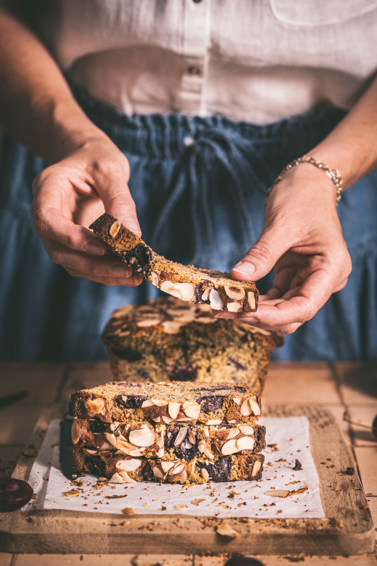 hands in frame holding a slice of cherry bread