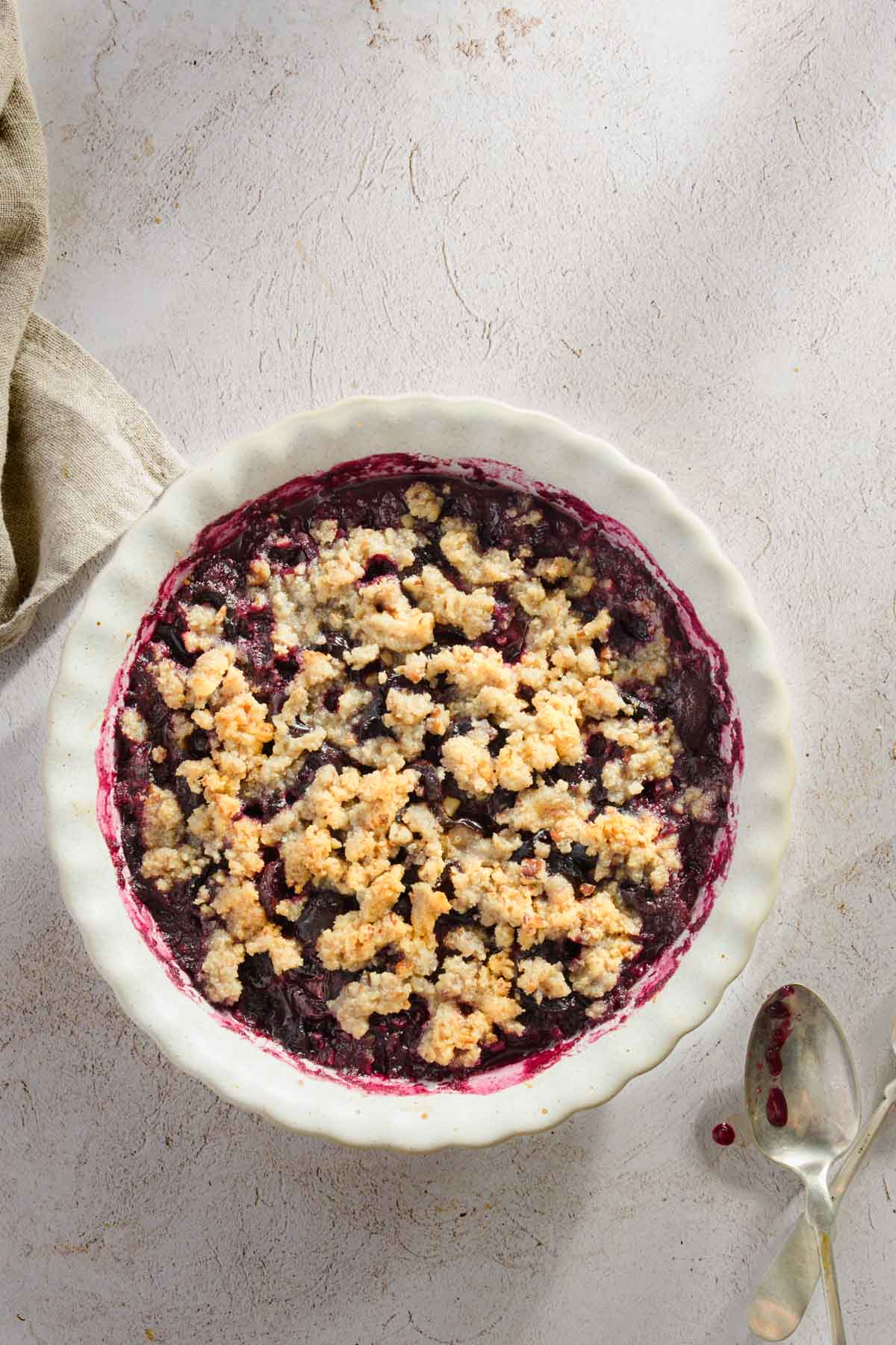 baked cherry crisp shown in a serving dish, light background