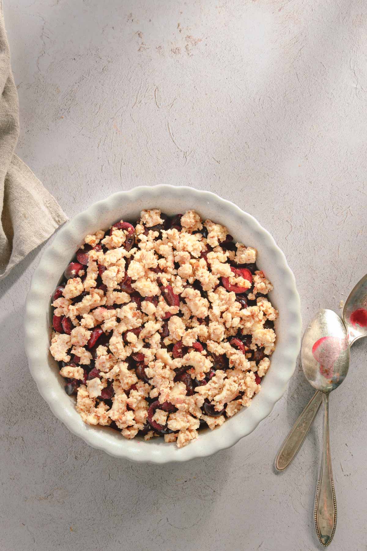 cherry filling in the baking dish topped with the crumble