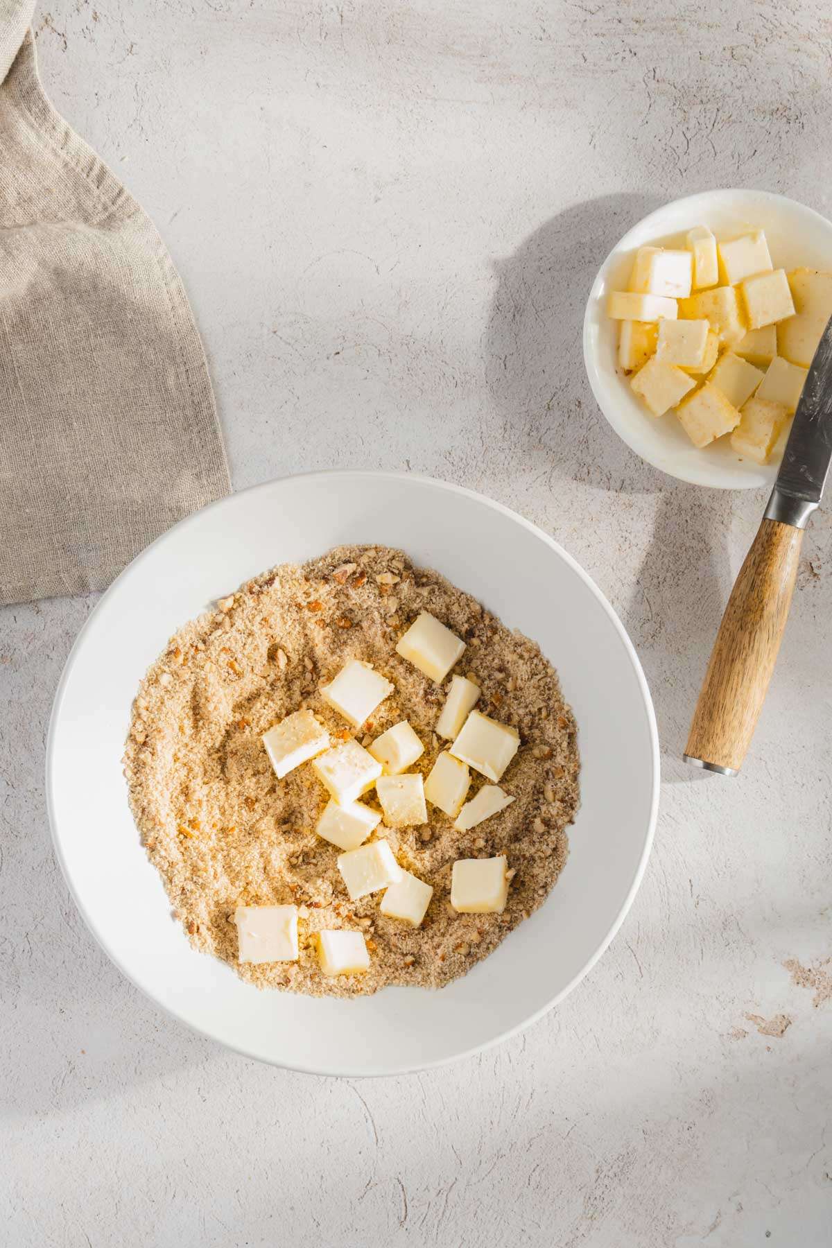 bowl with crumble ingredients and butter cubes in it