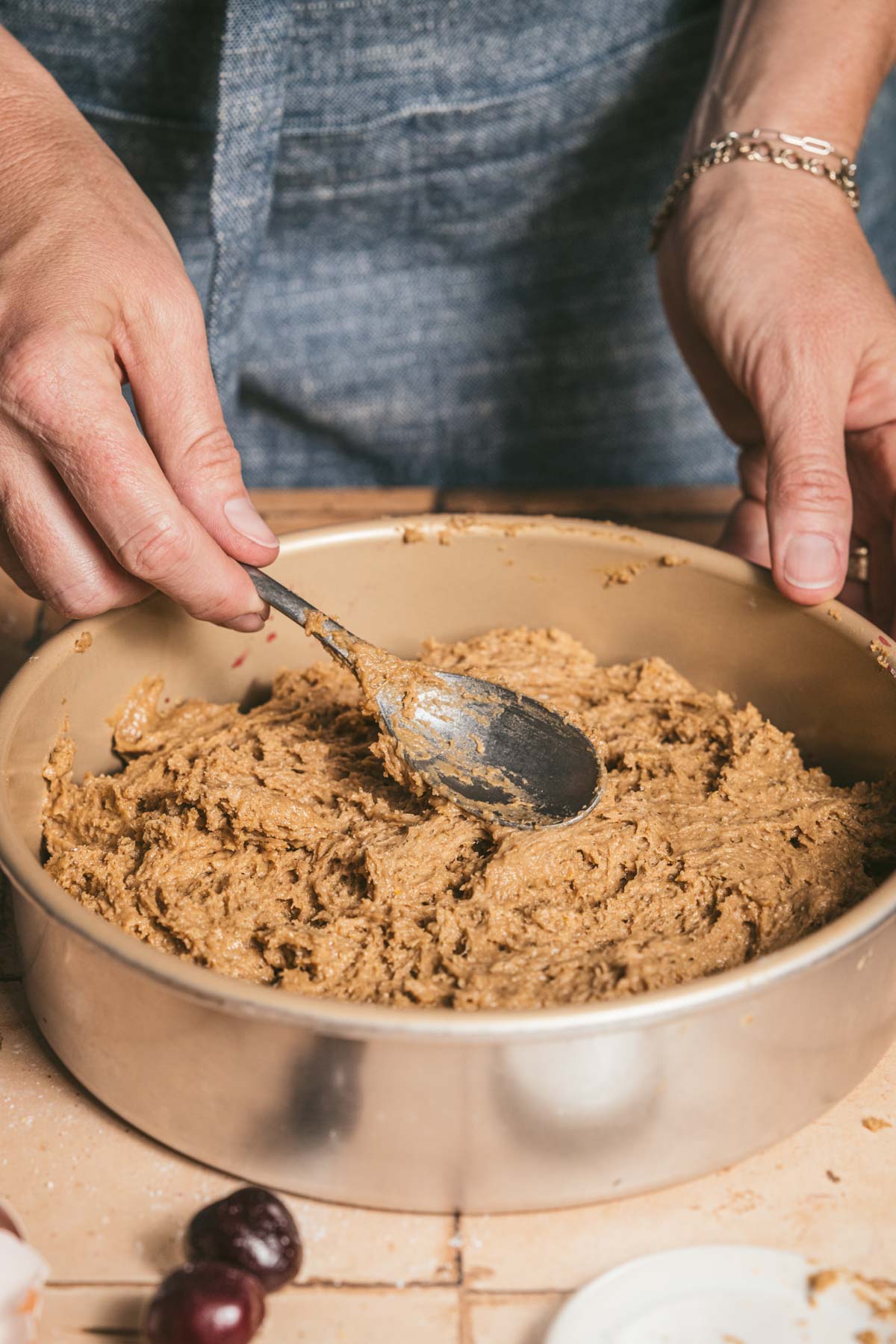hands in frame smoothing batter in the baking pan