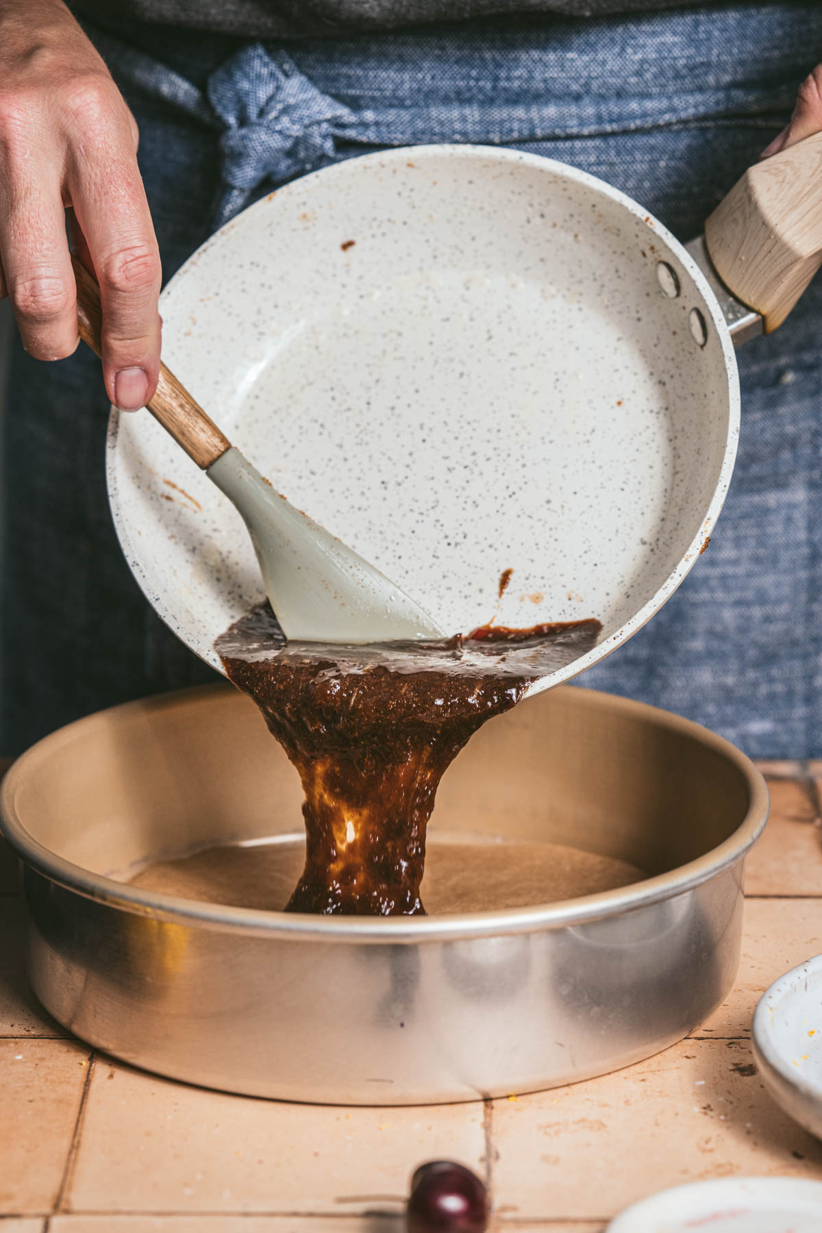 hands in frame holding pan and pouring caramel into a pan