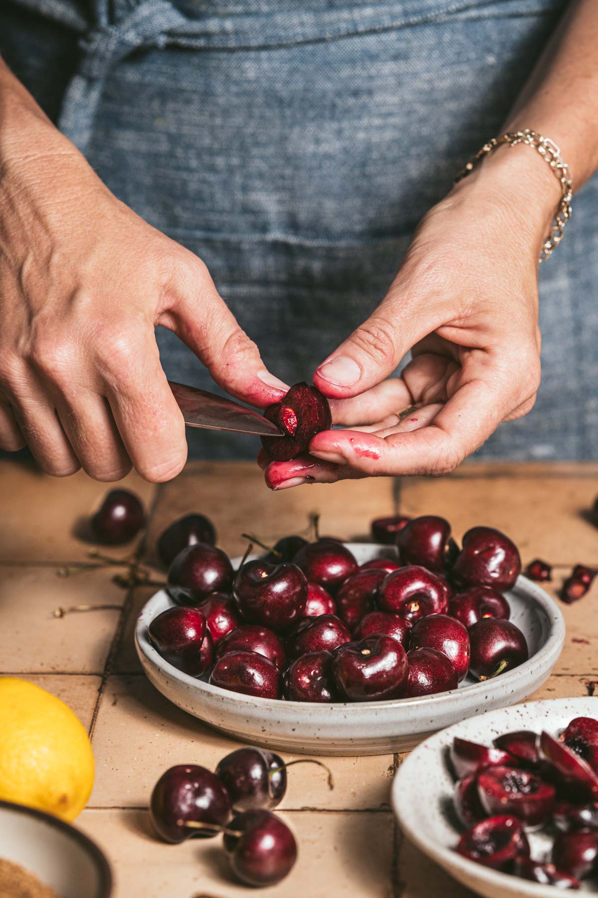 hands in frame pitting cherries