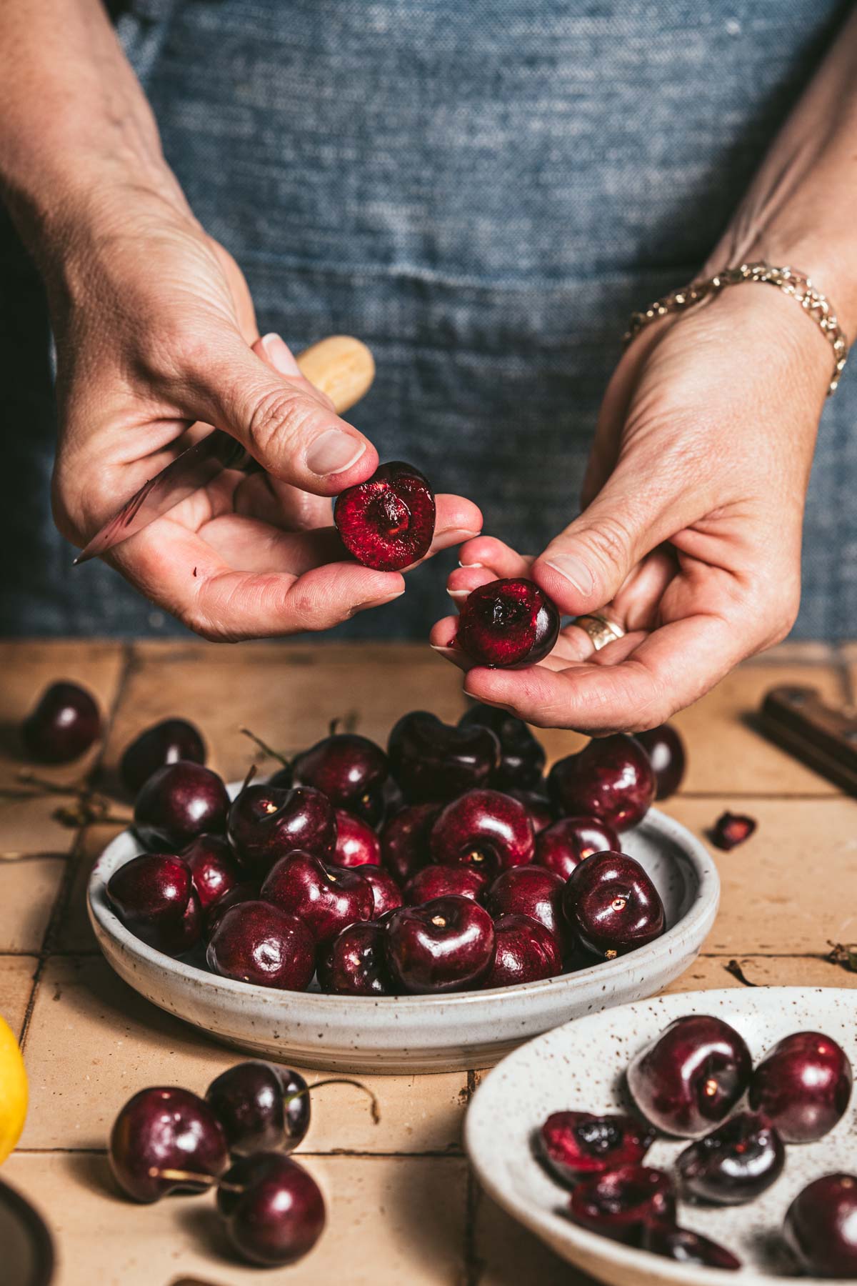 hands in frame holding pitted cherry