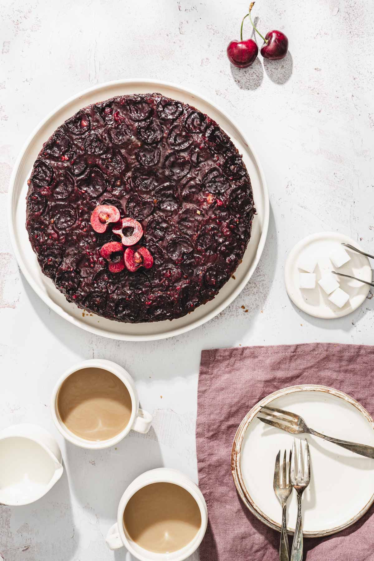 baked cherry upside down cake, serving plates, cups with coffee