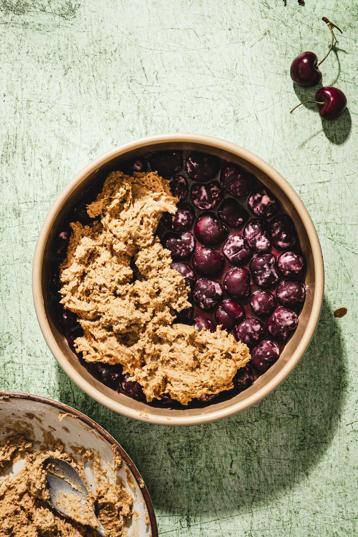 cake pan with partailly added batter over the cherries