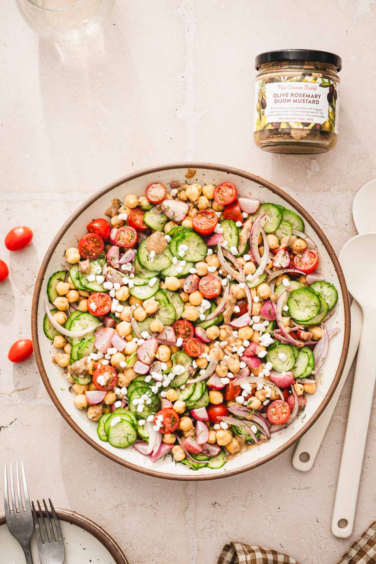 topview of a large bowl wiht the salad, jar with mustard