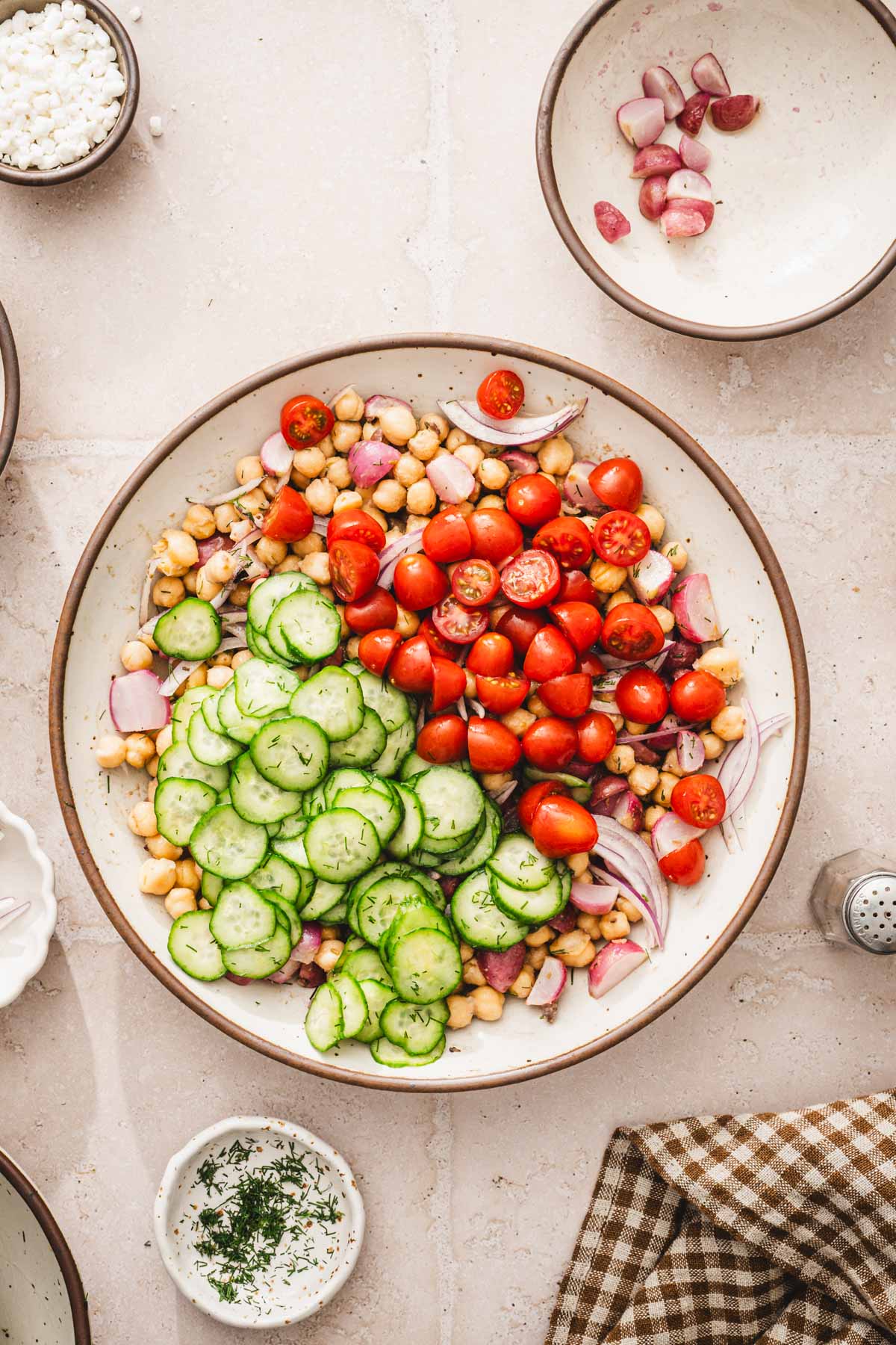large bowl with the chickpes and tomatoes and cucumbers added