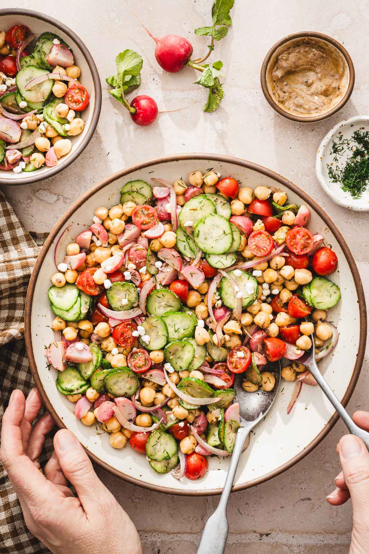 round large bowl with the salad, hands in frame