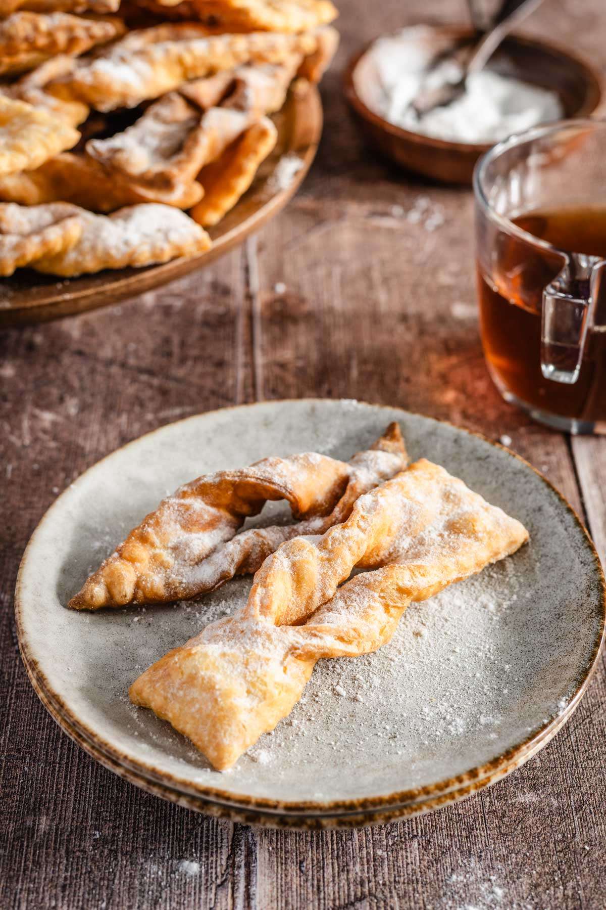 small plate with chrusciki, glass with tea