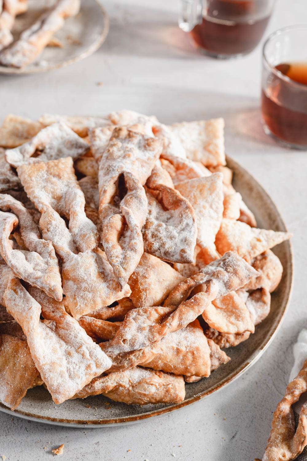 chrusciki on a plate, glasses with tea