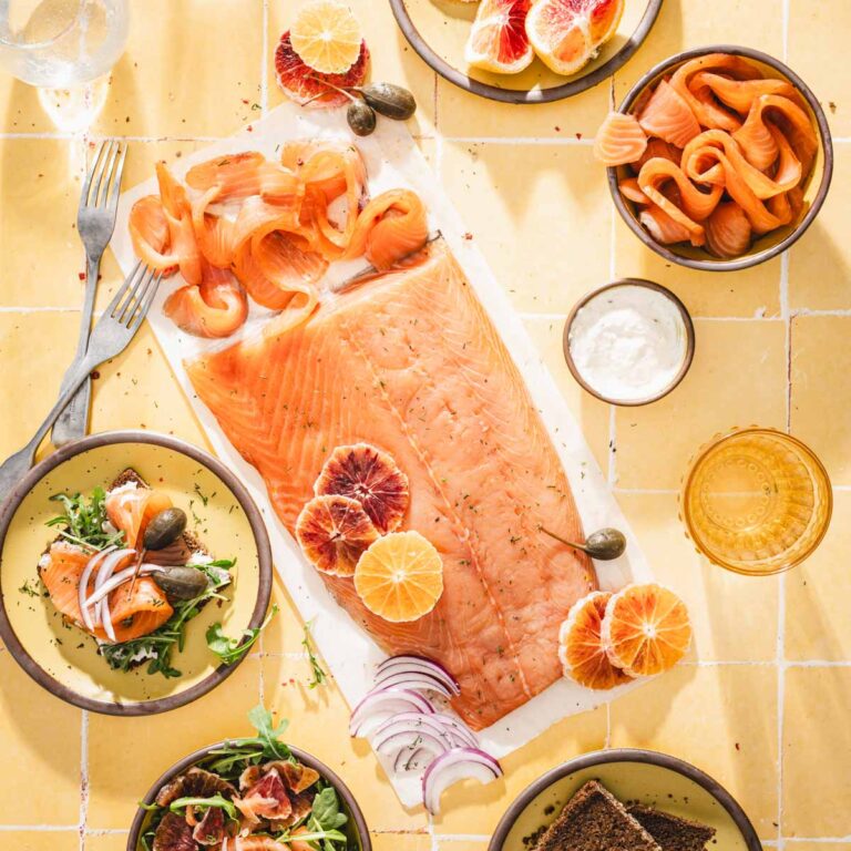 cured salmon on parchment paper, serving plates around