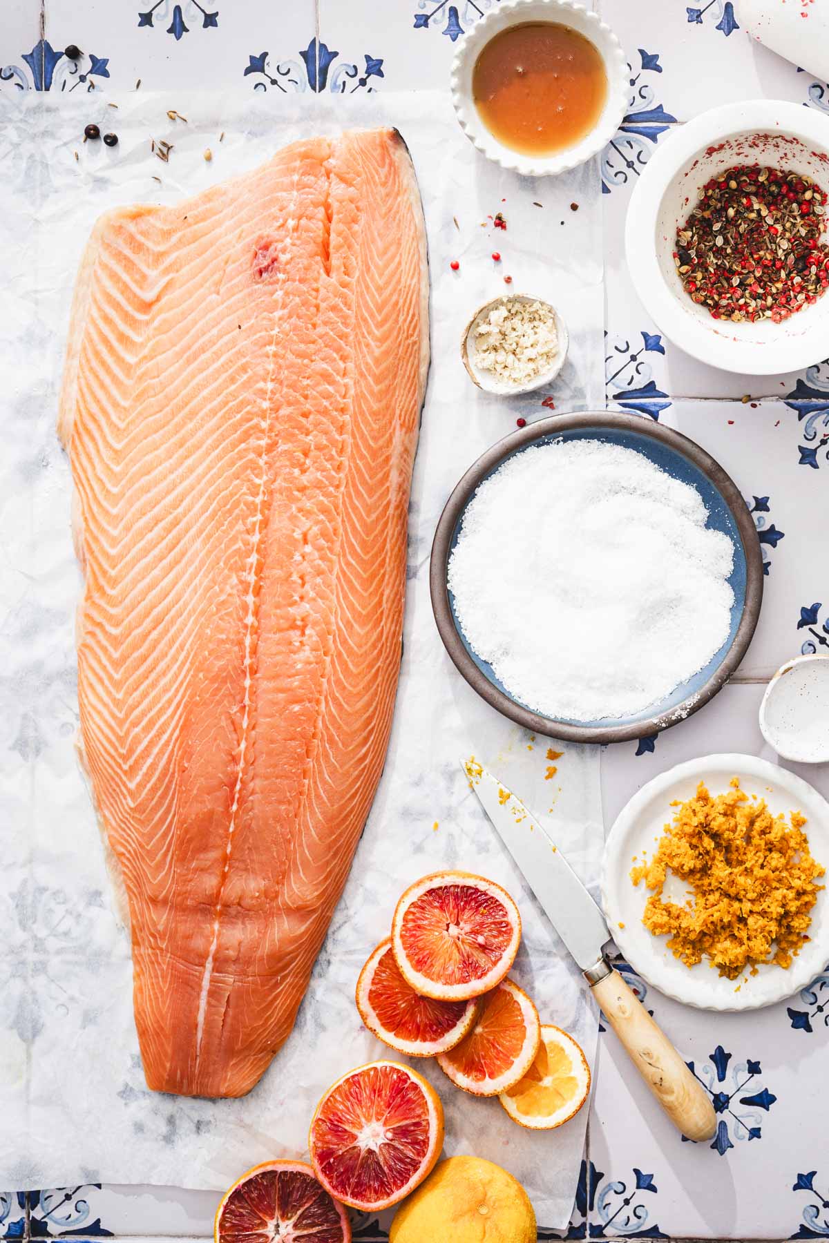 raw salmon on a parchemnt paper with various ing around