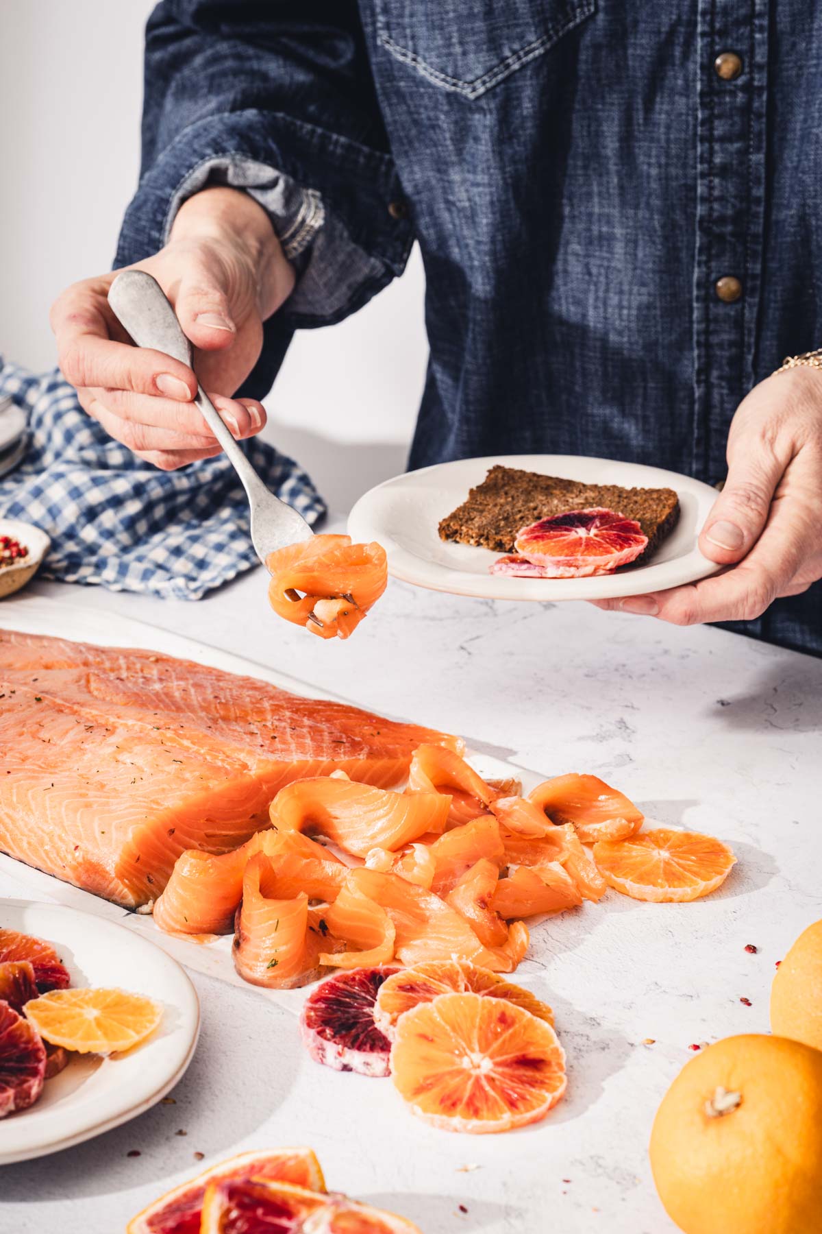 hand in frame holding fork with a piece of salmon
