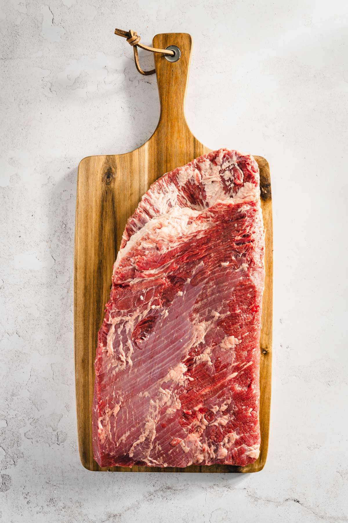 whole raw brisket on the cutting board, after trimming