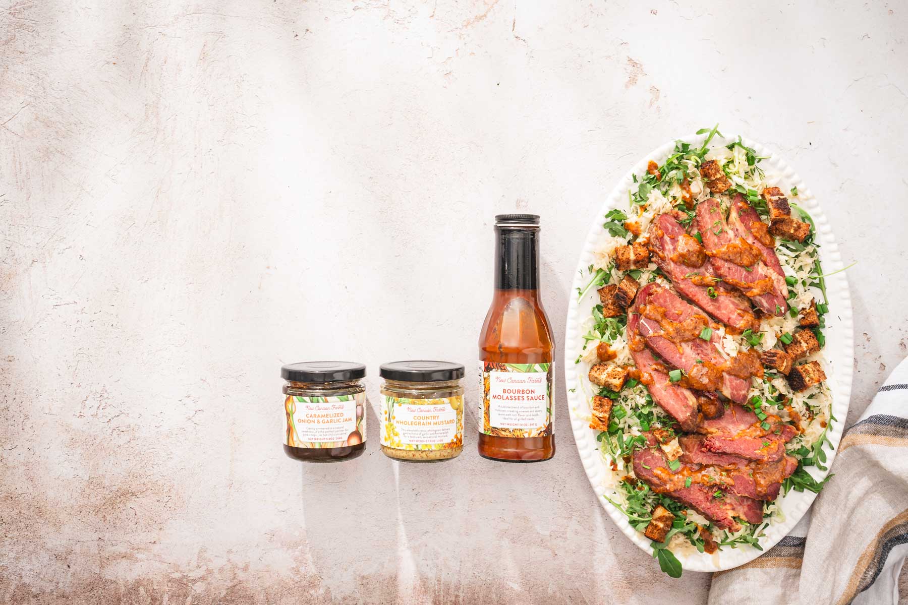 two jars and a bottle with NCF products, platter with the salad