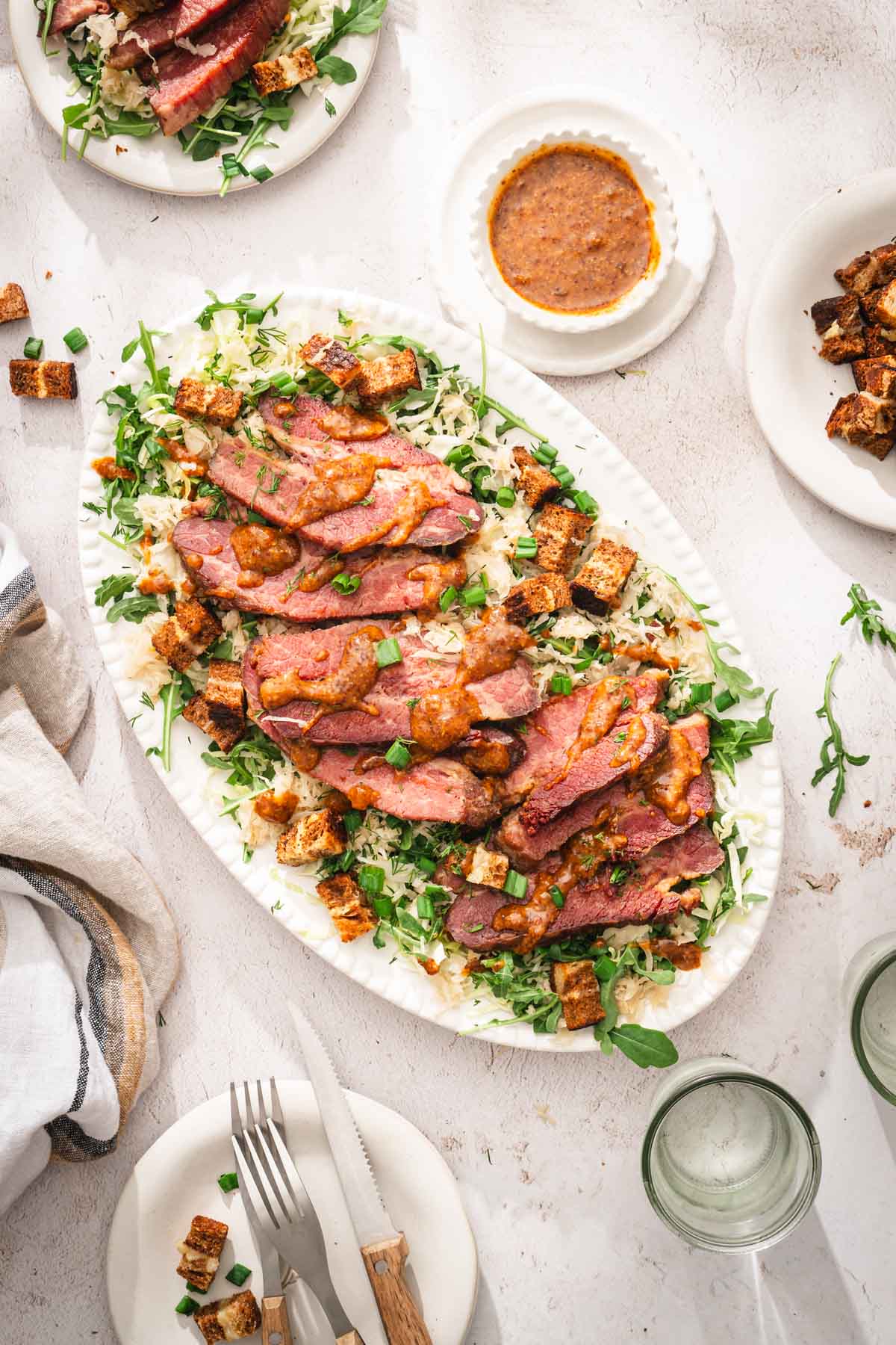 platter with cornd beef salad, napking, plates, dish with the sauce