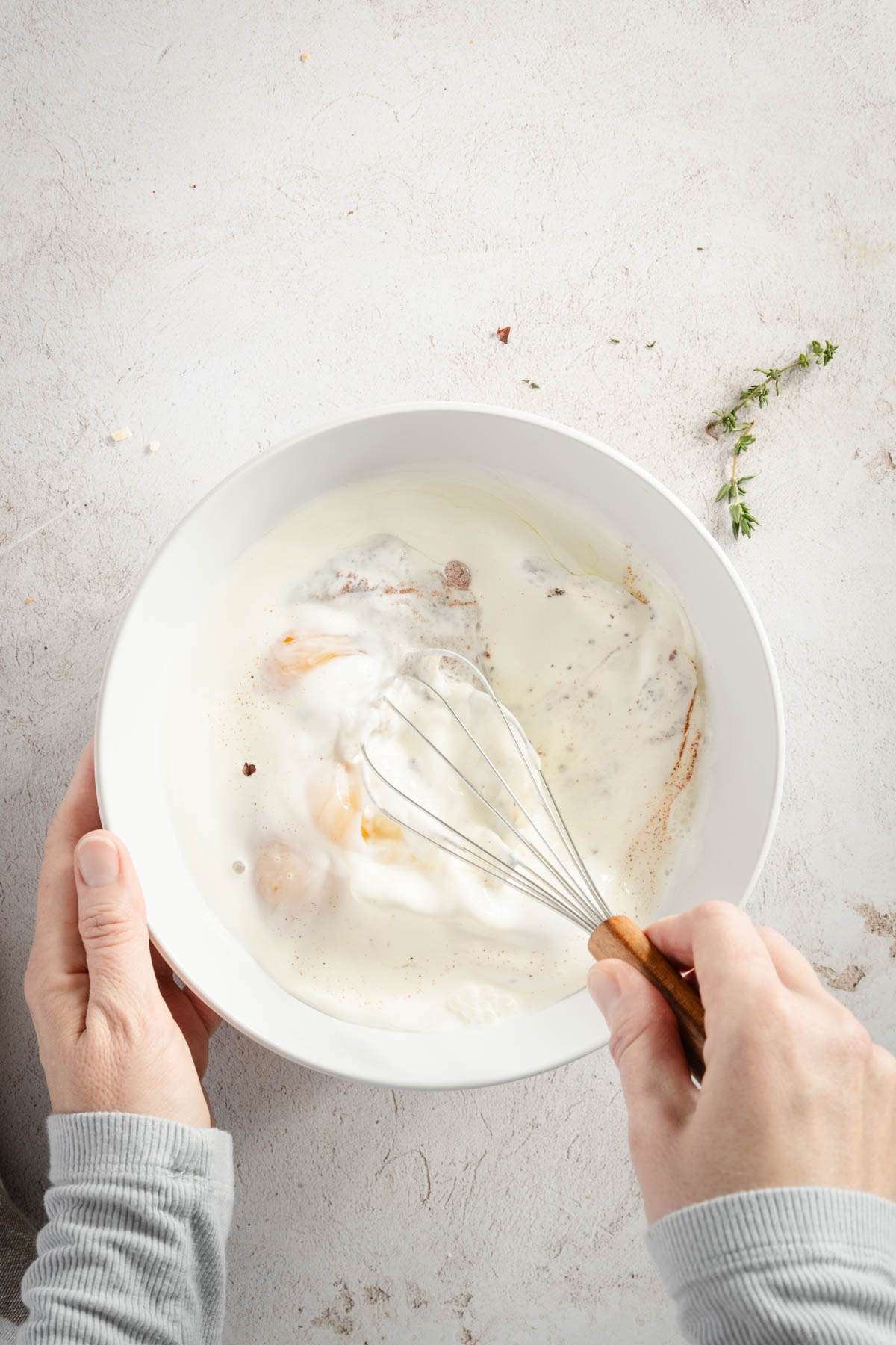 hands in frame whisking liquid ingredients for the croissant bake