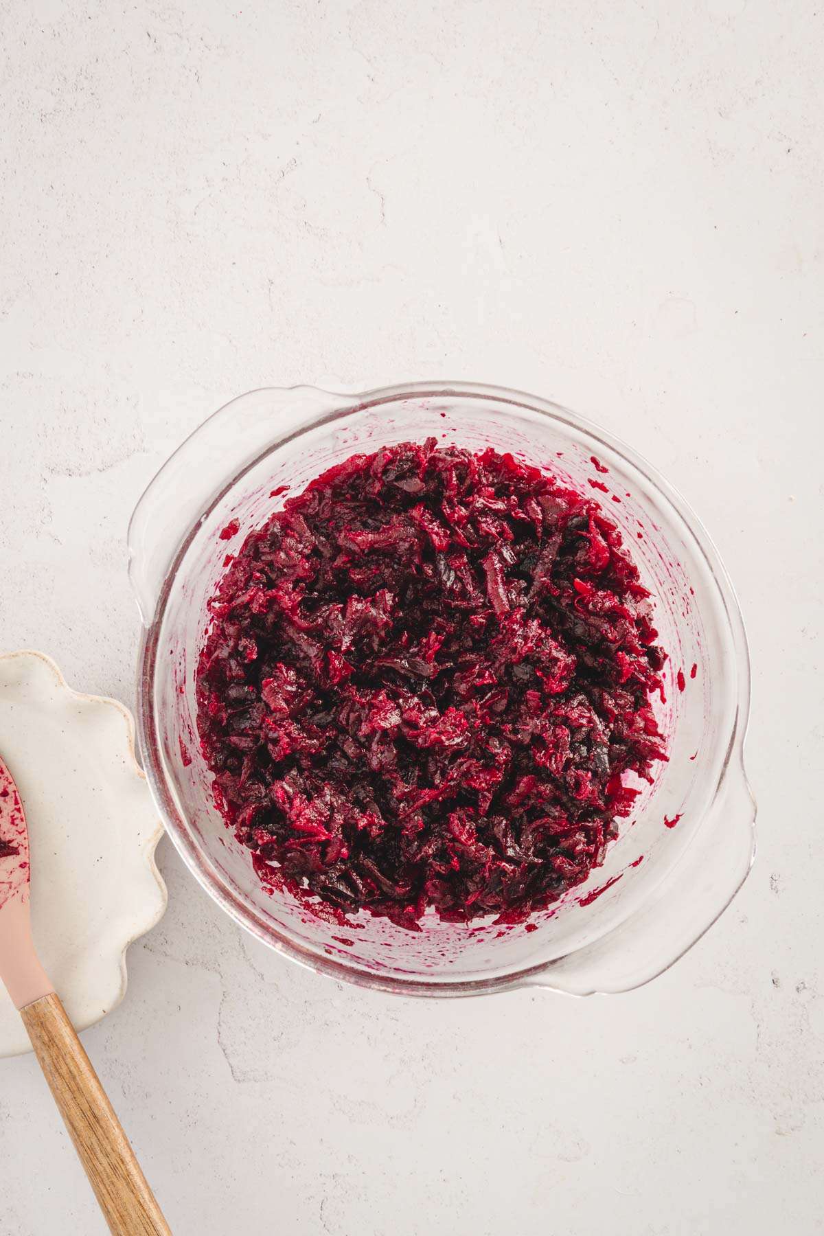 shredded beets and other ingredients mixed together in a glass bowl