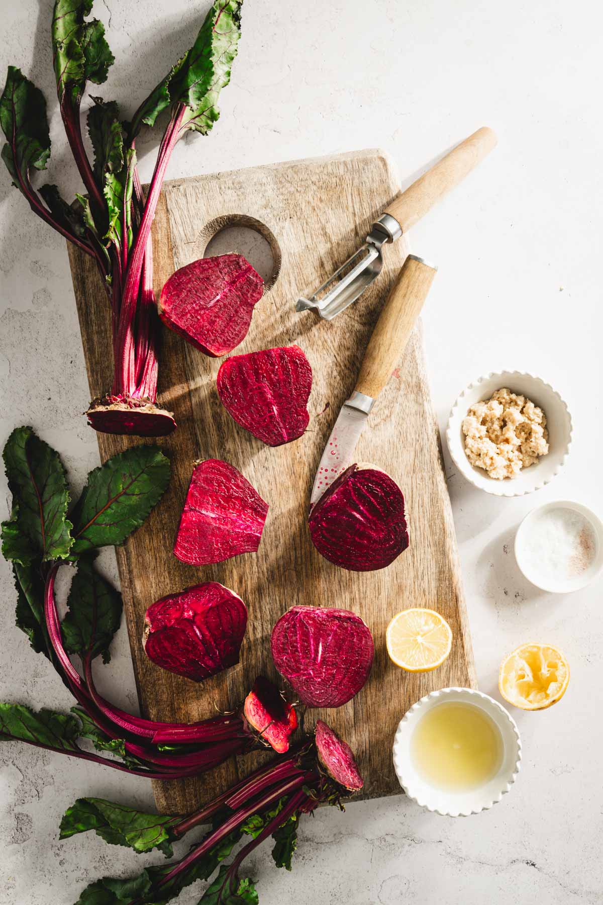 raw beets cut in half on a cutting board