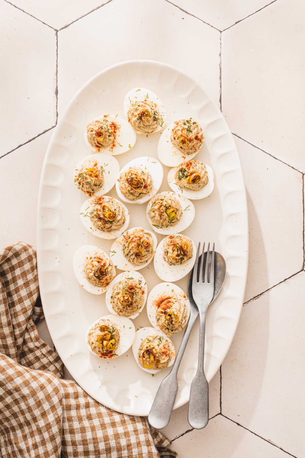 deviled eggs on a srving platter, spoon adn fork in the corner