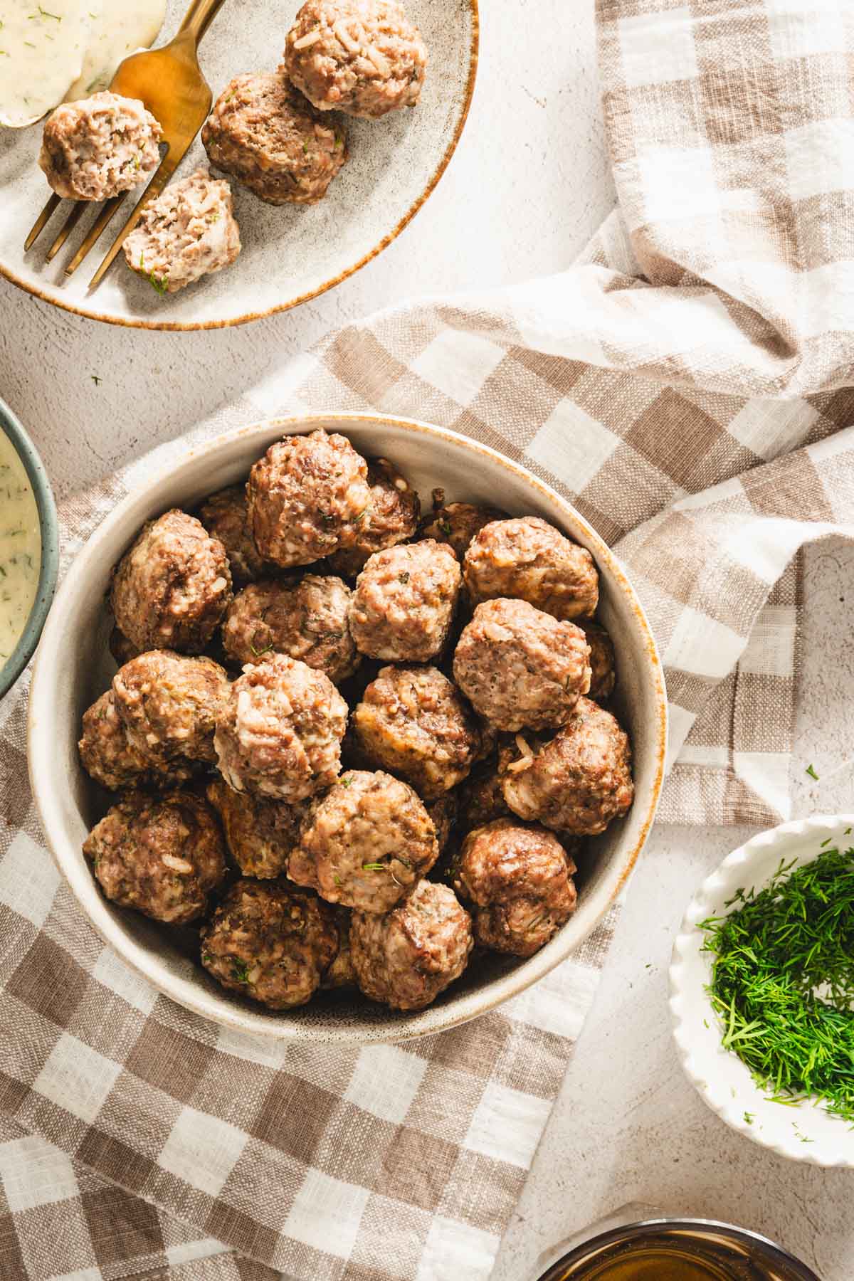 plane meatballs in a white bowl, placed over a napkin, top view