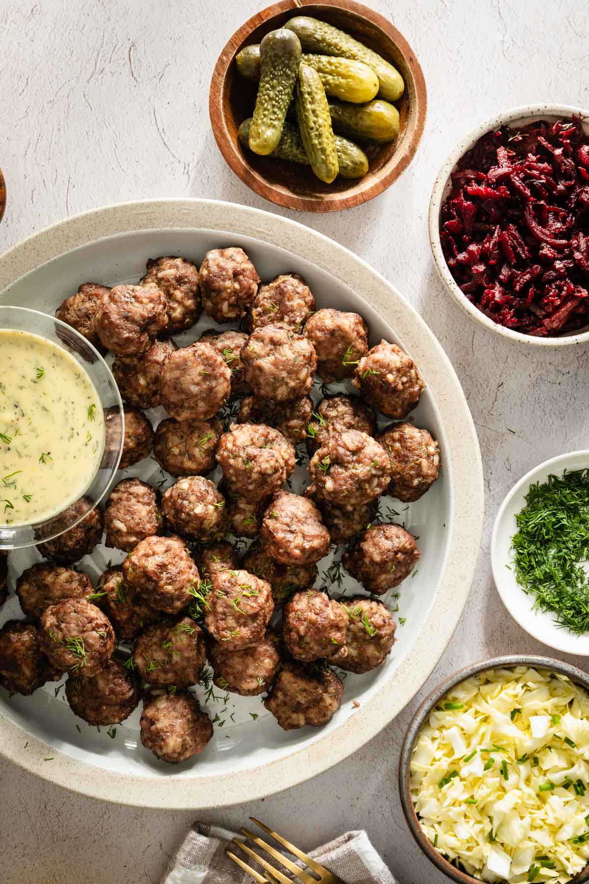 meatballs on a round plate with a dipping sauce placed to the side