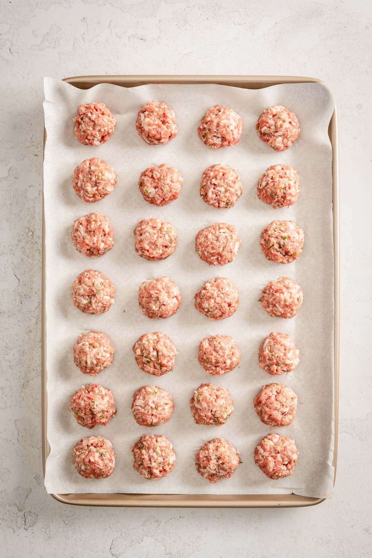 raw meatballs on a baking sheet