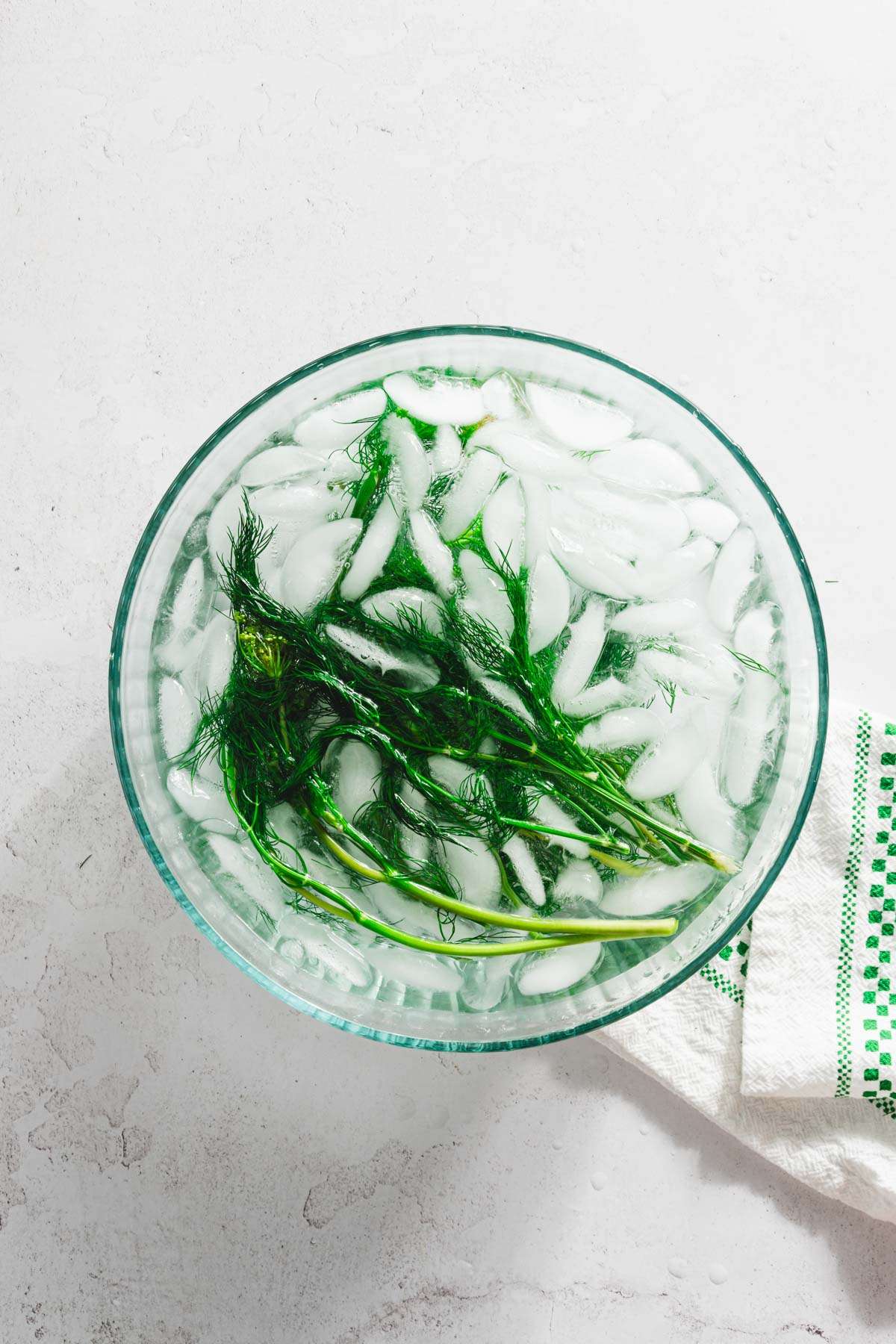 ice bath with ice cubes and blanched dill