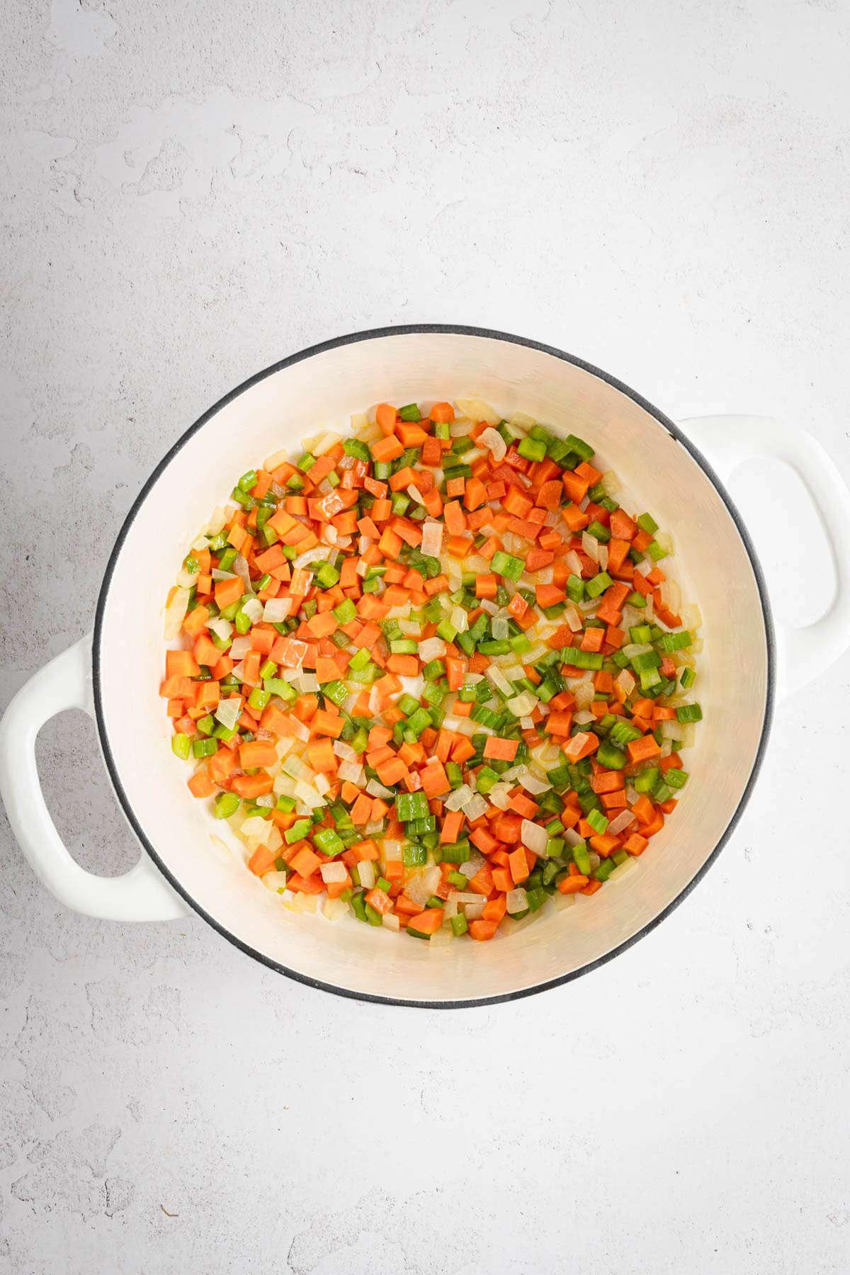 large stock pot with celery, onion and carrots cooked