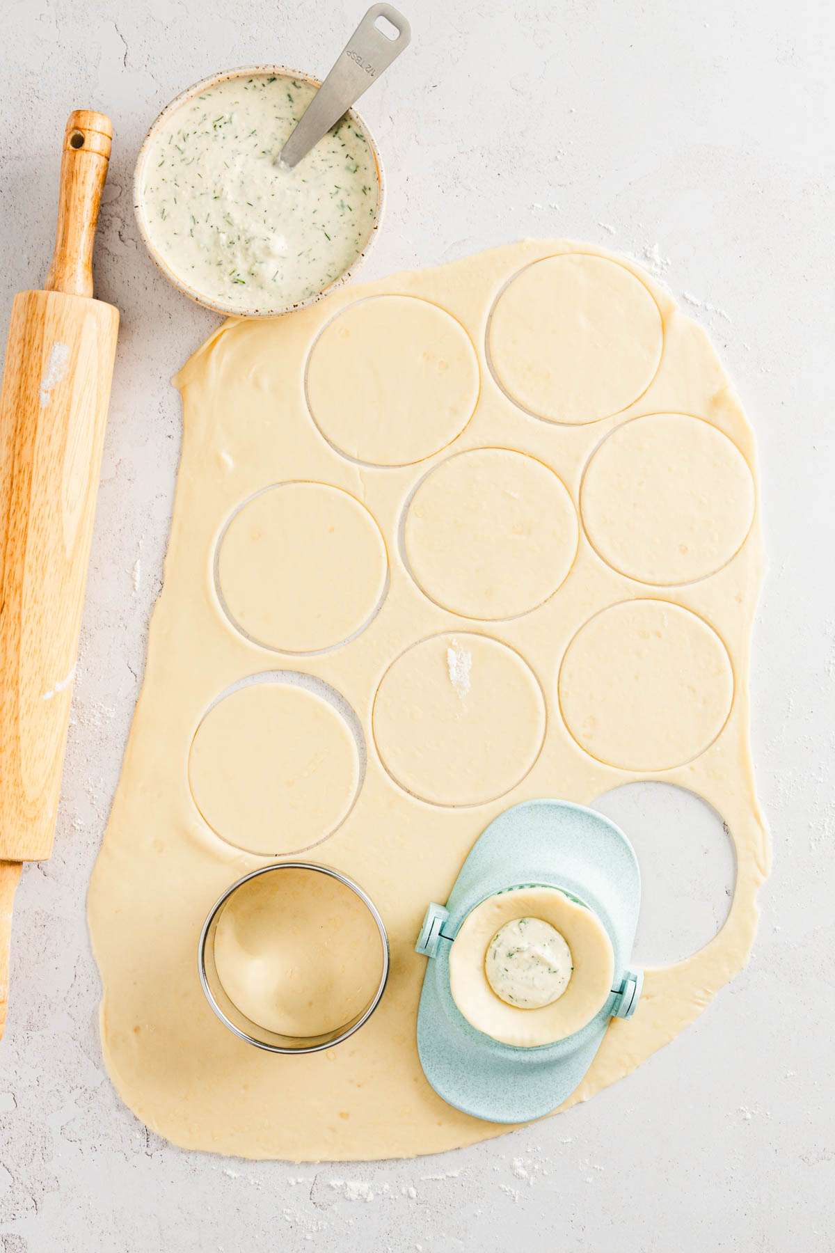 rolled out pierogi dough, cut out circles, pierogi form, dish with pierogi filling