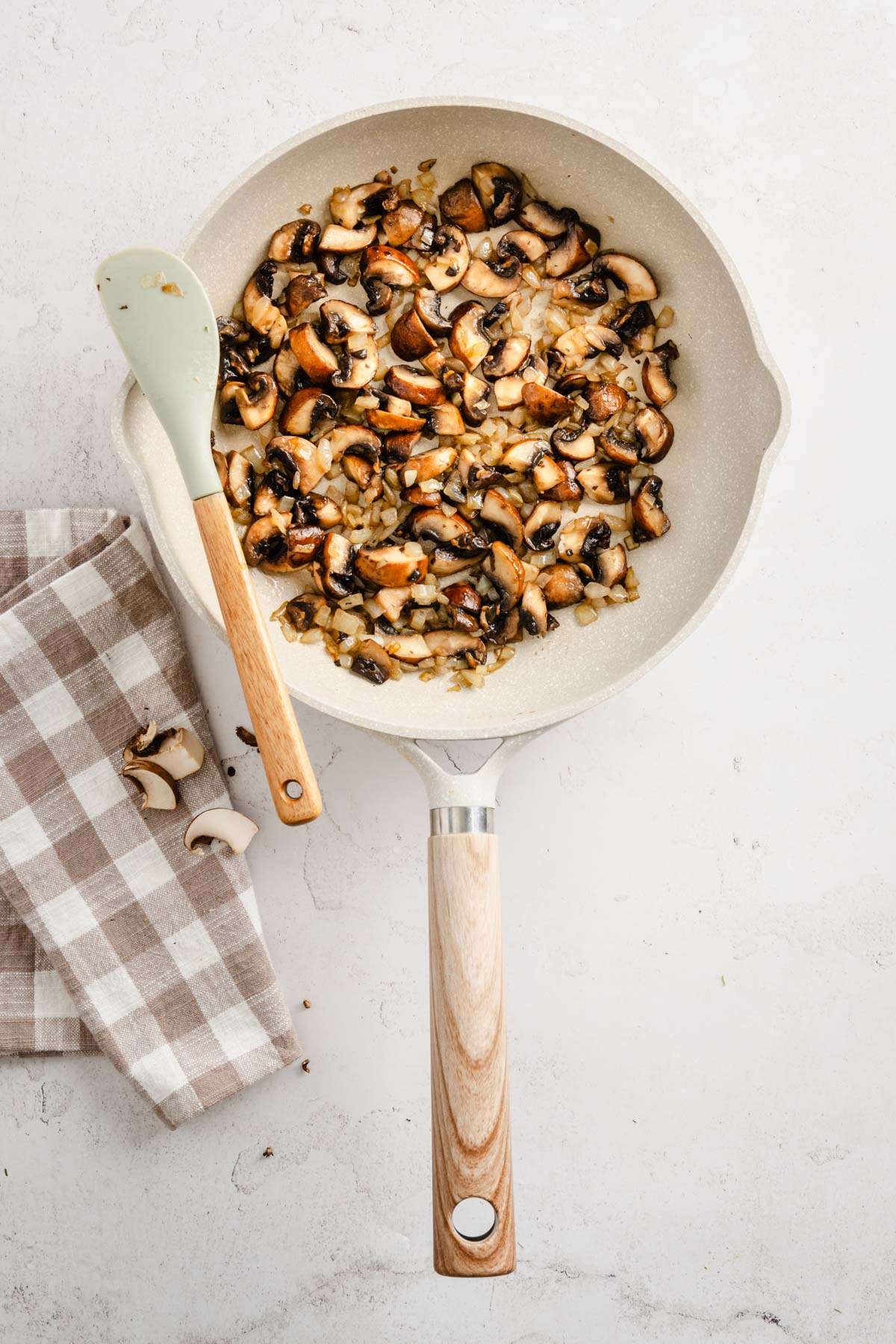 skillet with cooked mushrooms mixed with onion