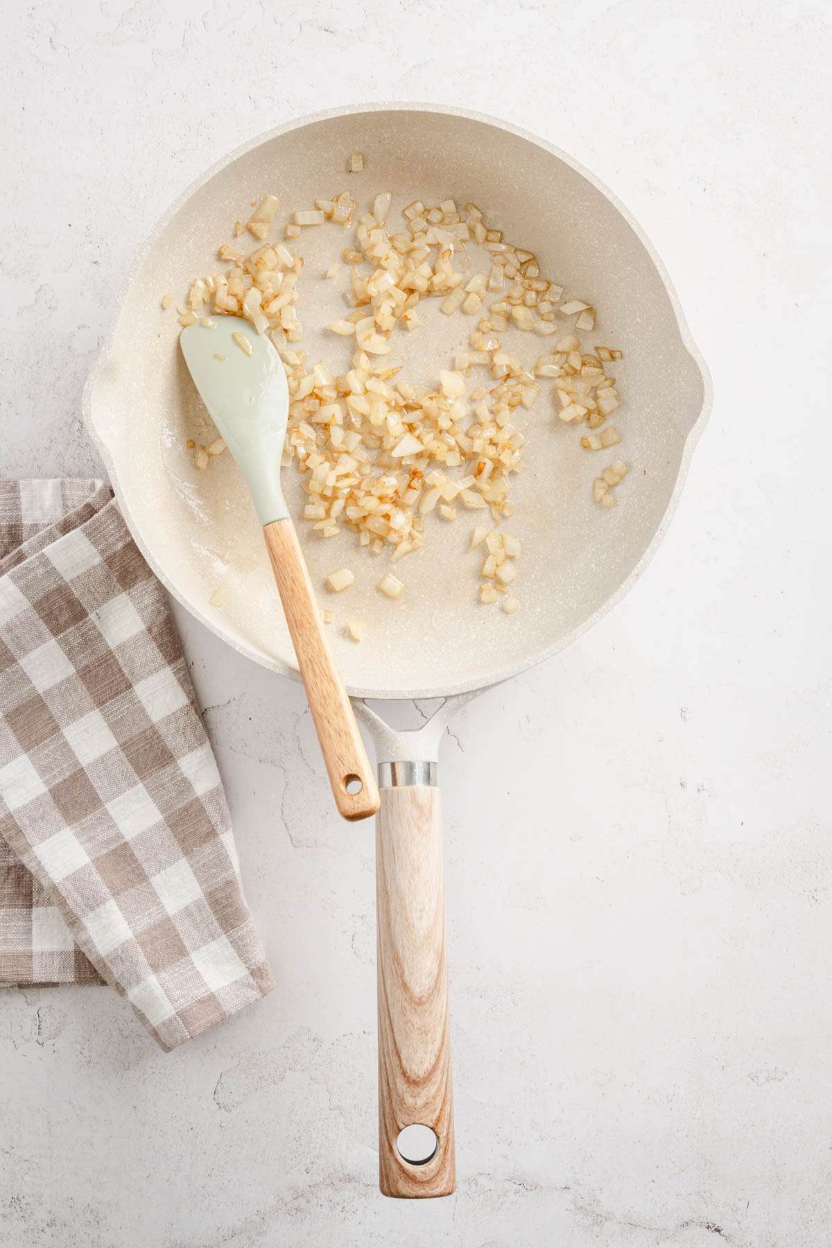 skillet with cooked onion, spatula, napkin