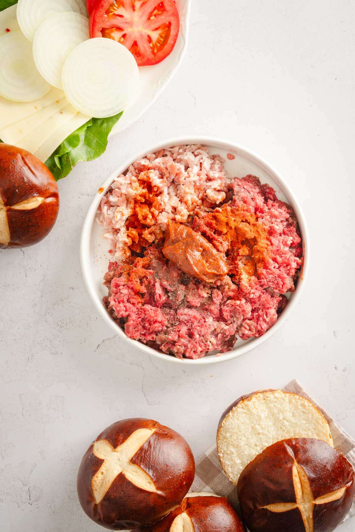 large bowl with the ground meat, and other ingredients added on top