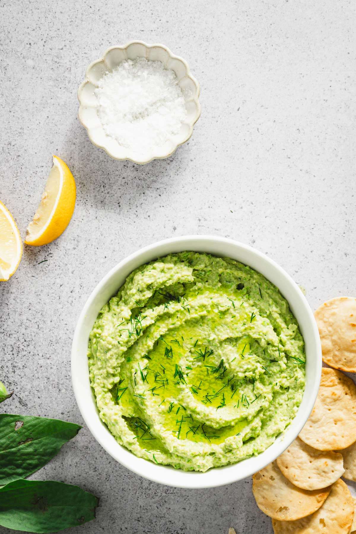 bowl with fava bean hummus, salt, lemon wedges, crackers