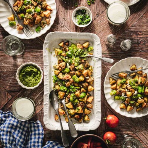 fava bean salad on a serving platter, various plate around