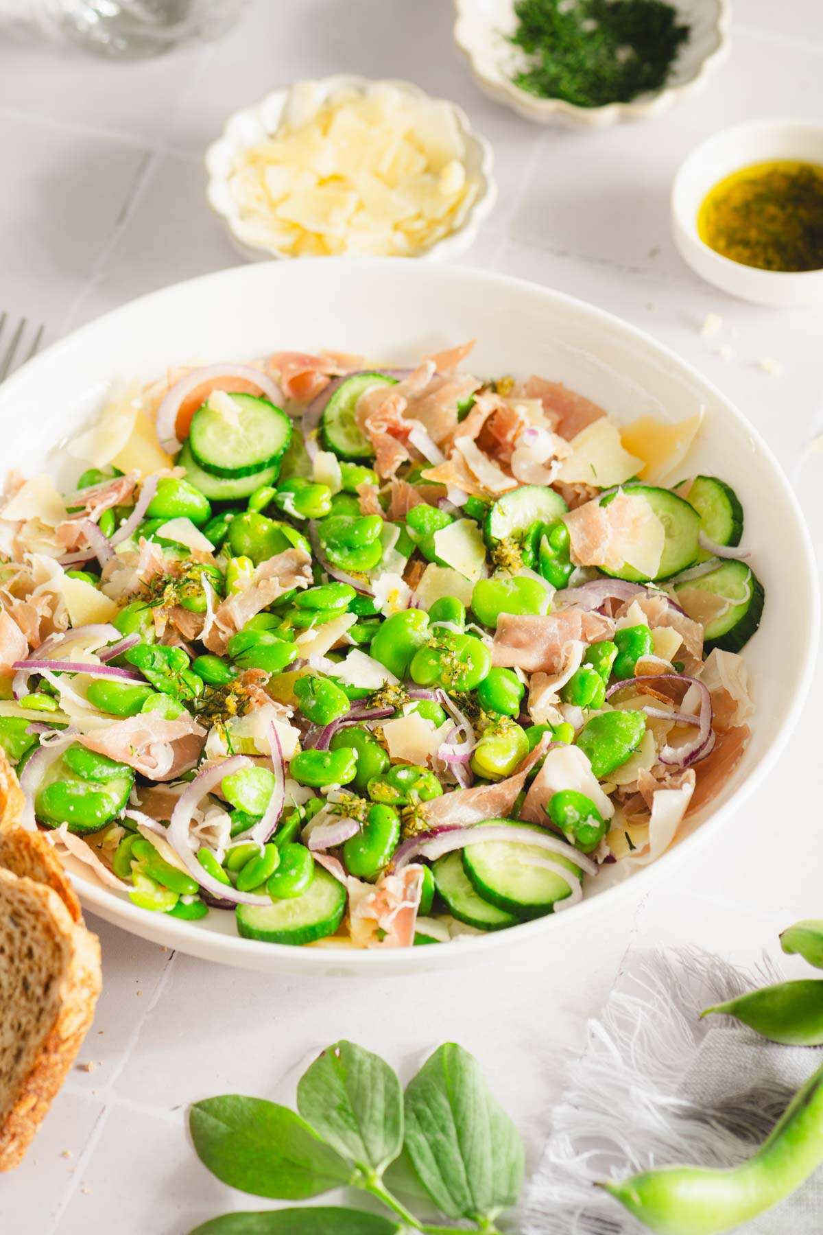 fava bean salad served in a bowl, dish with parm cheese, and the dressing