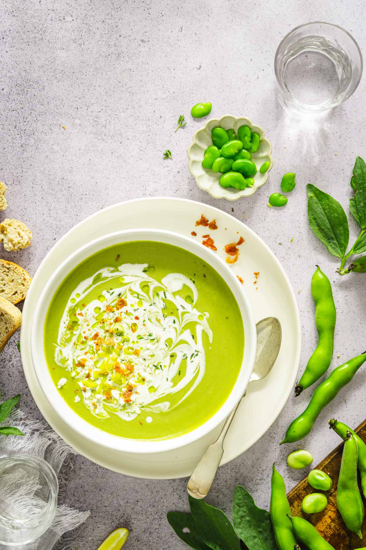 bowl with fava bean soup, garnished with cream, prosciutto