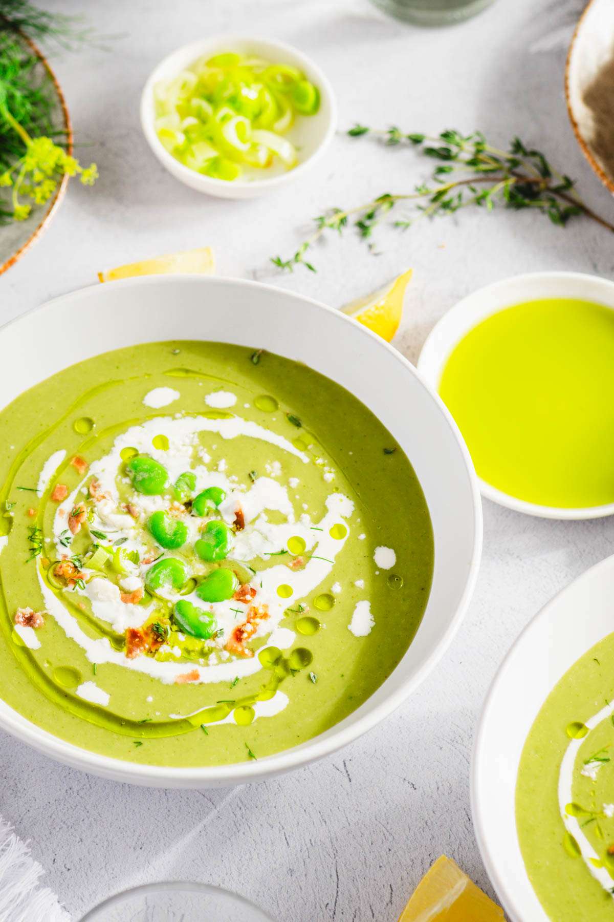 close up of fava bean soup in a serving bowl, dish with dill oil