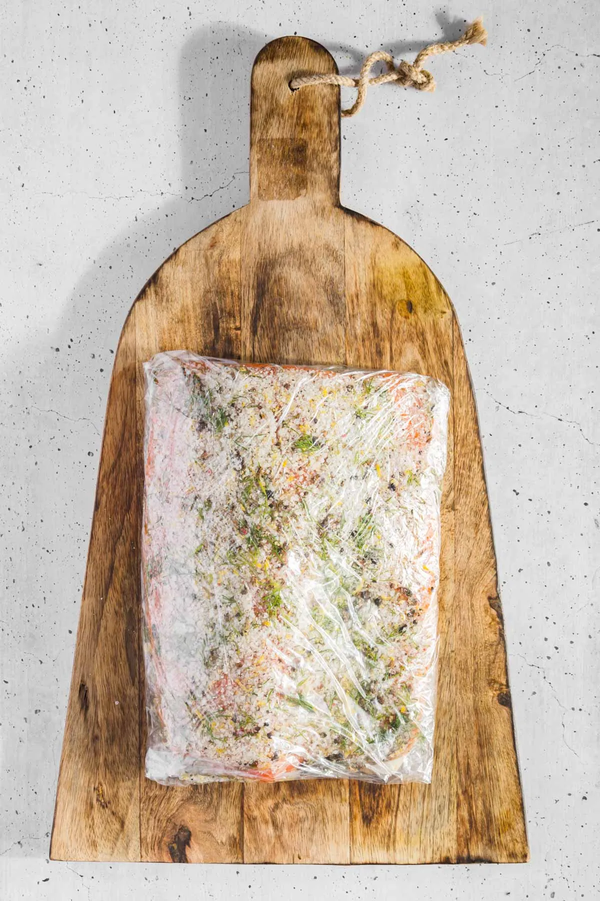salmon covered in cure wrapped in plastic wrap