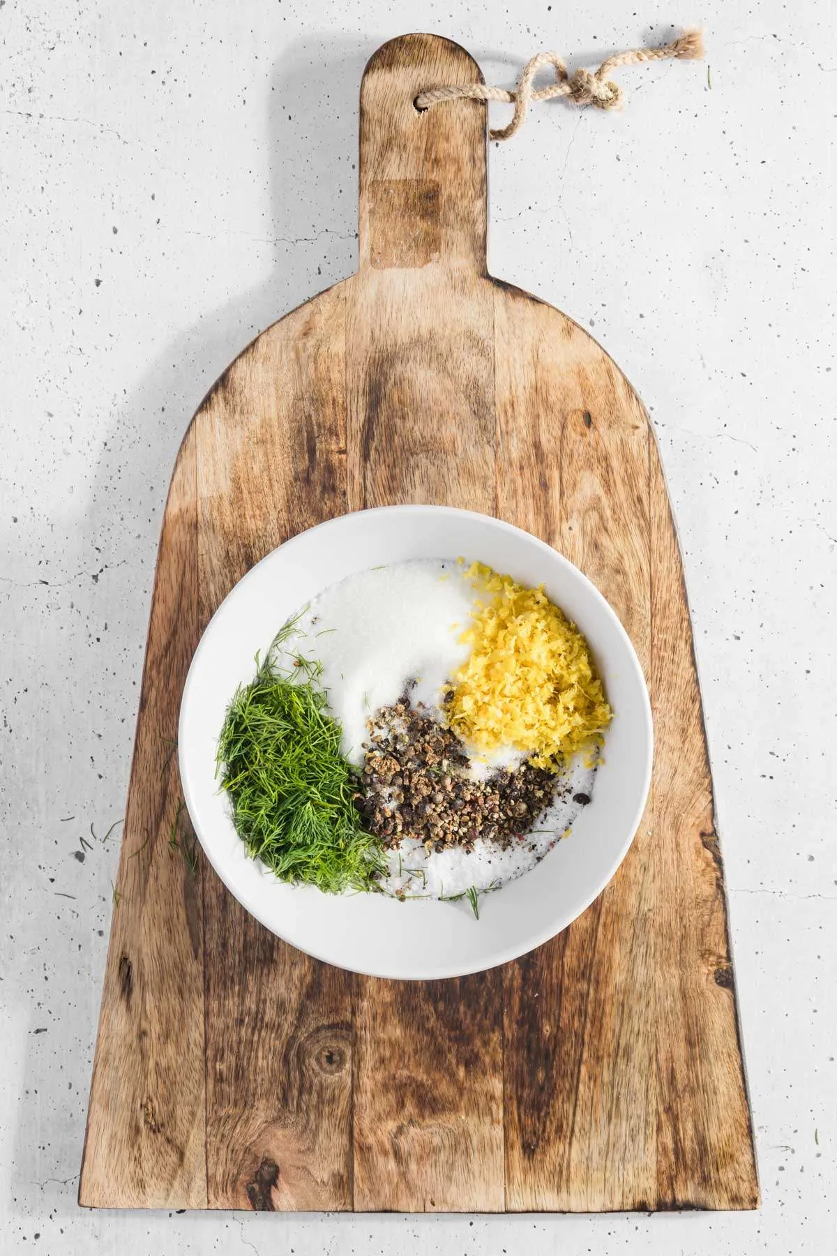 bowl with all the ingredients for the cure set on a wooden cutting board
