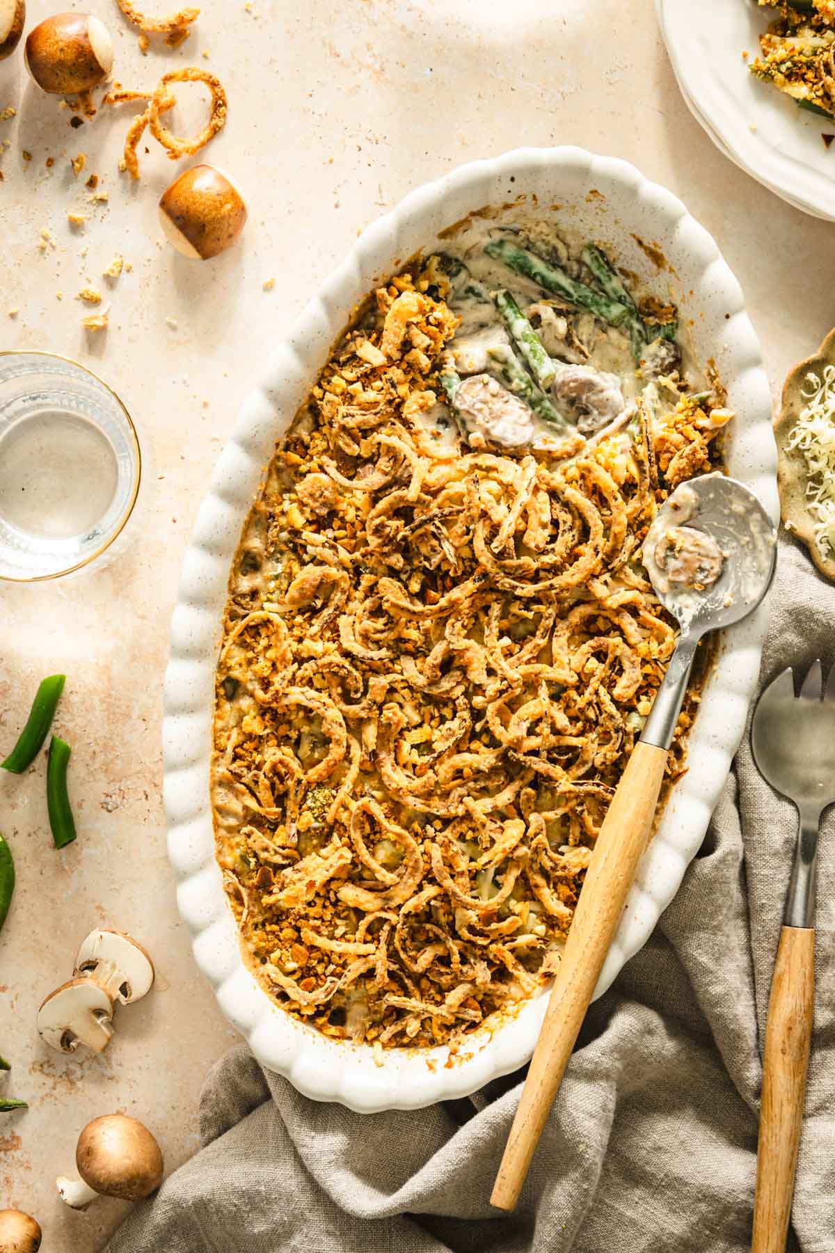 baked green bean casserole presented in the deep dish, serving spoons, napkin, plate with casserole