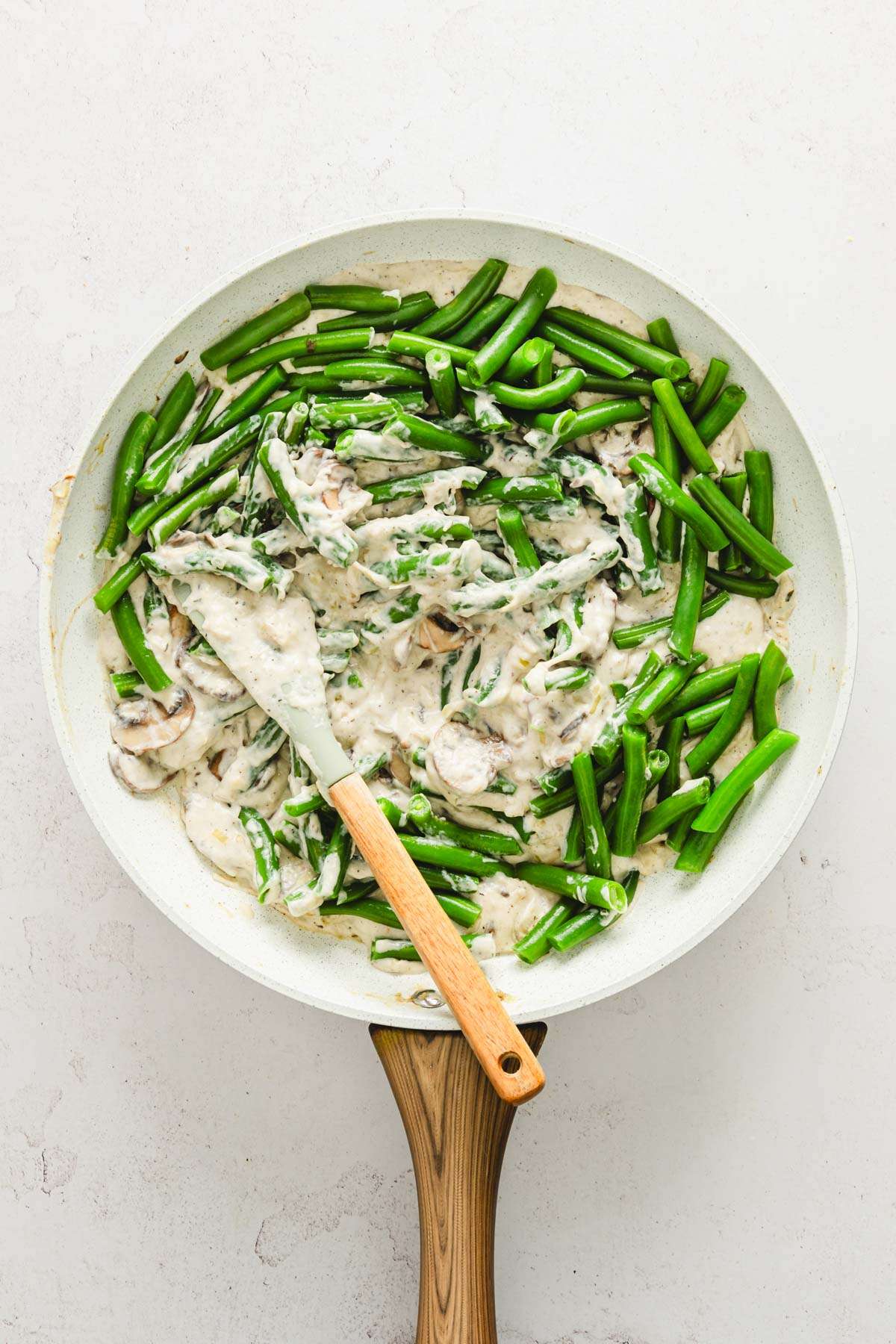 skillet with green beans added to mushroom sauce