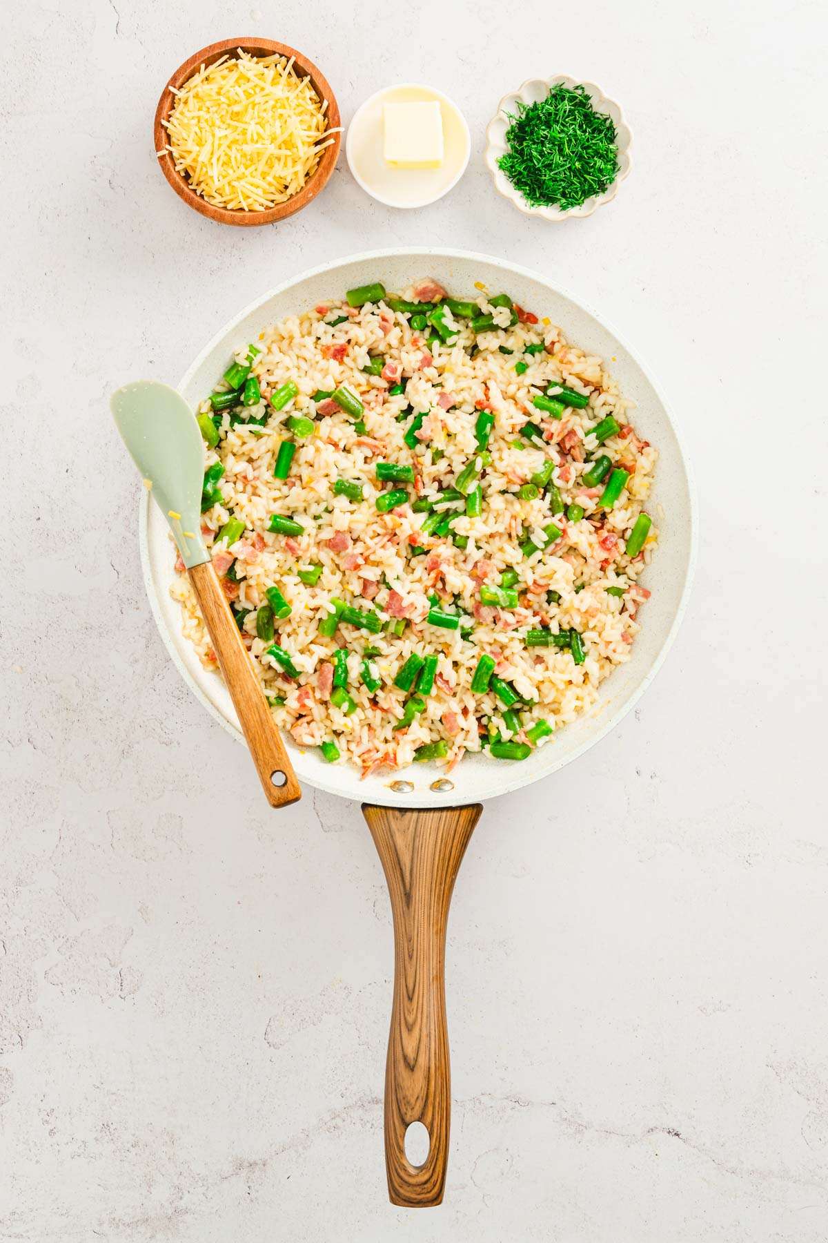 pan with risotto and dishes with cheese, butter and fresh dill