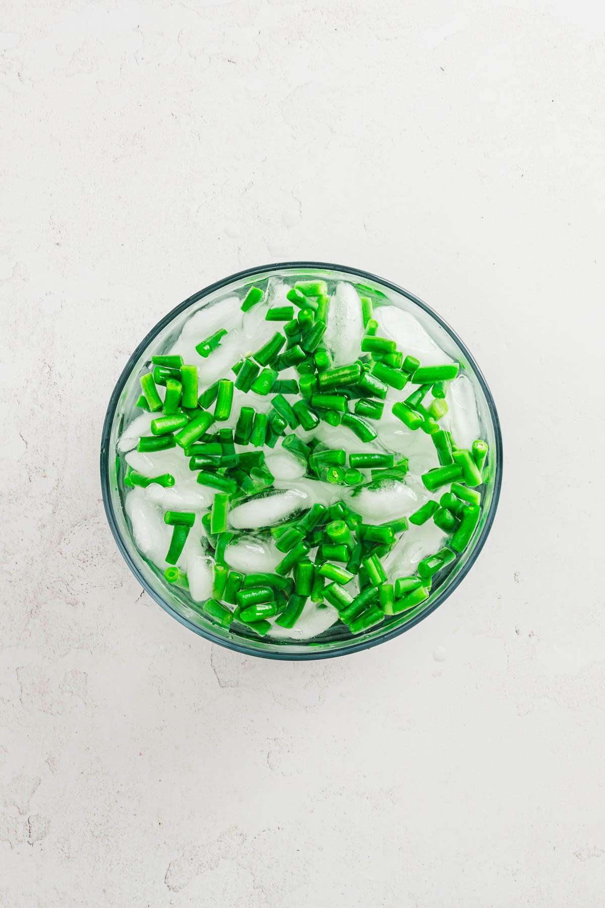 glass bowl with ice water and green beans