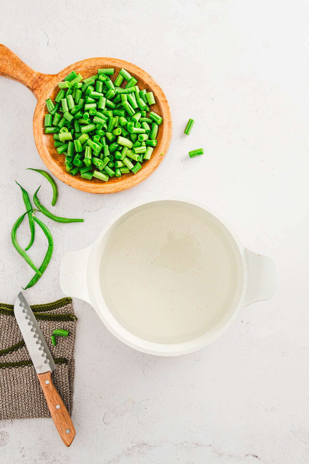 cooking pan with water, dish with cut up green beans