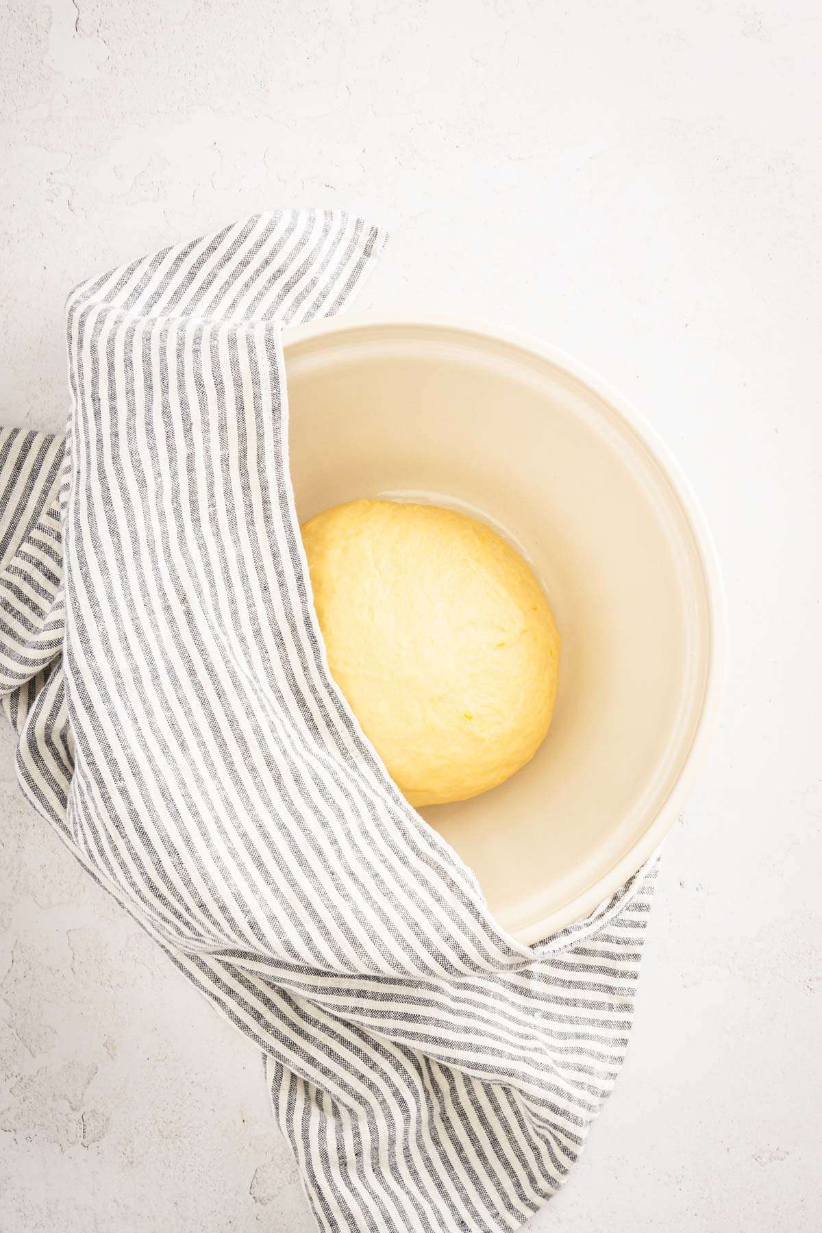 shaped dough on a bowl, before rising, kitchen towel