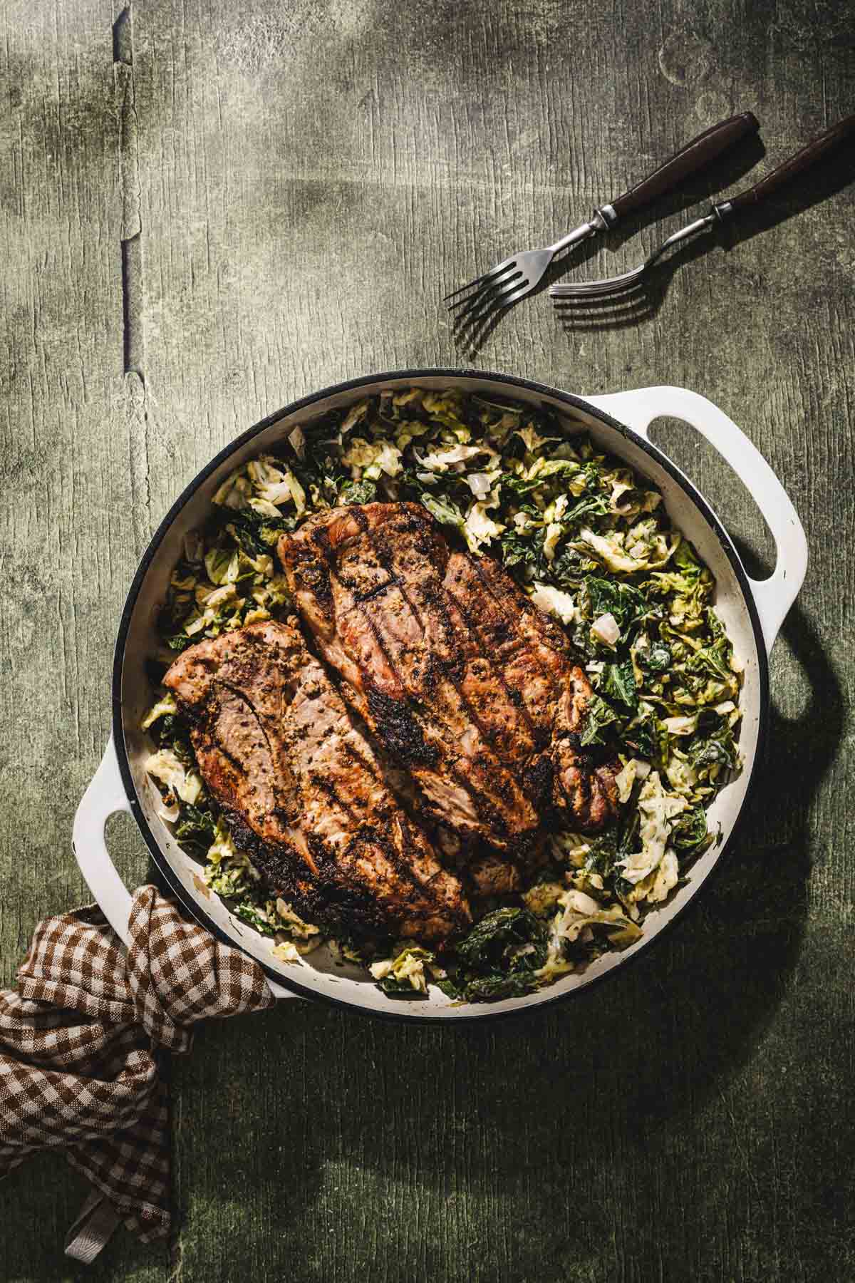 rilled karkowka on a pan with braised cabbage