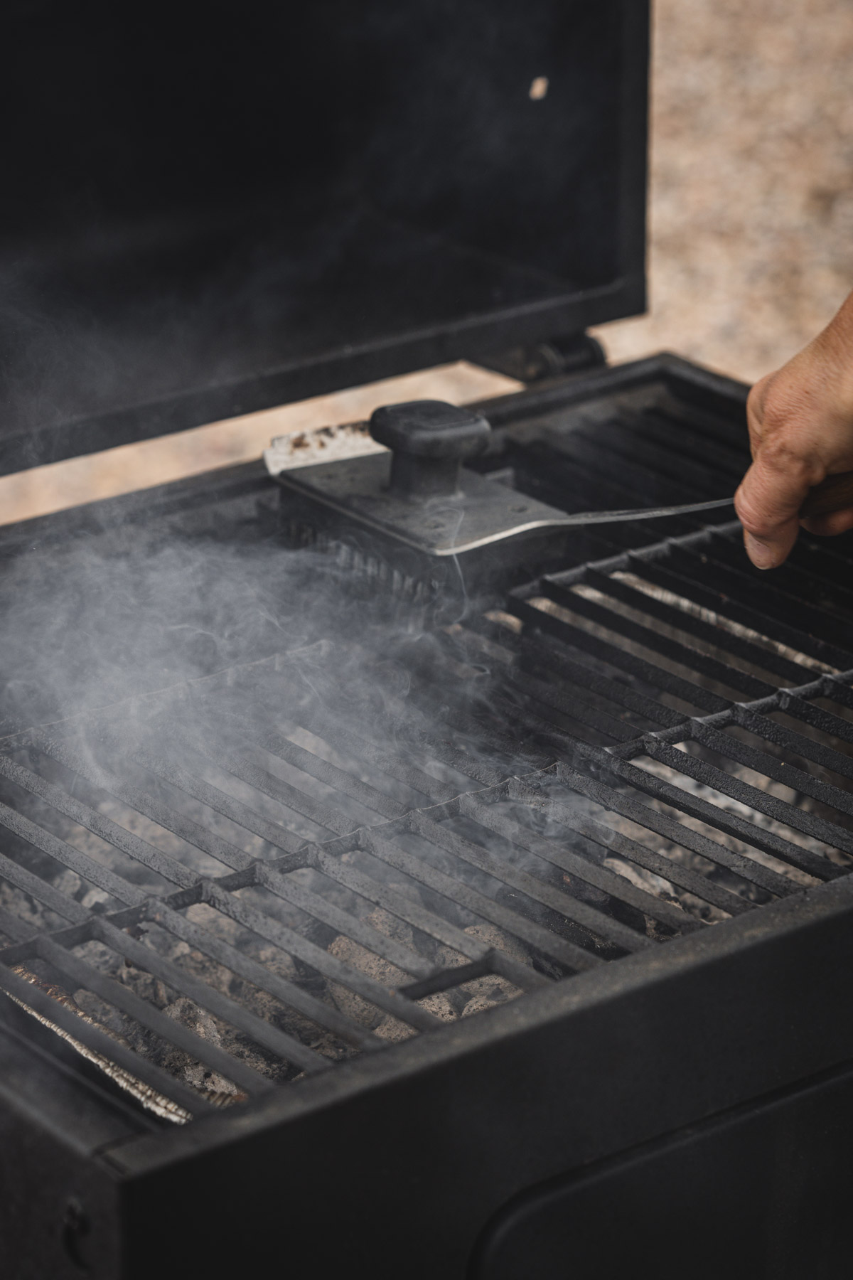 hands in frame cleaning the grill