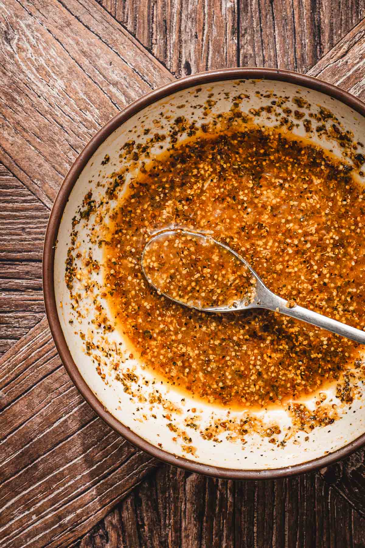 close up of a bowl with the marinade and spoon